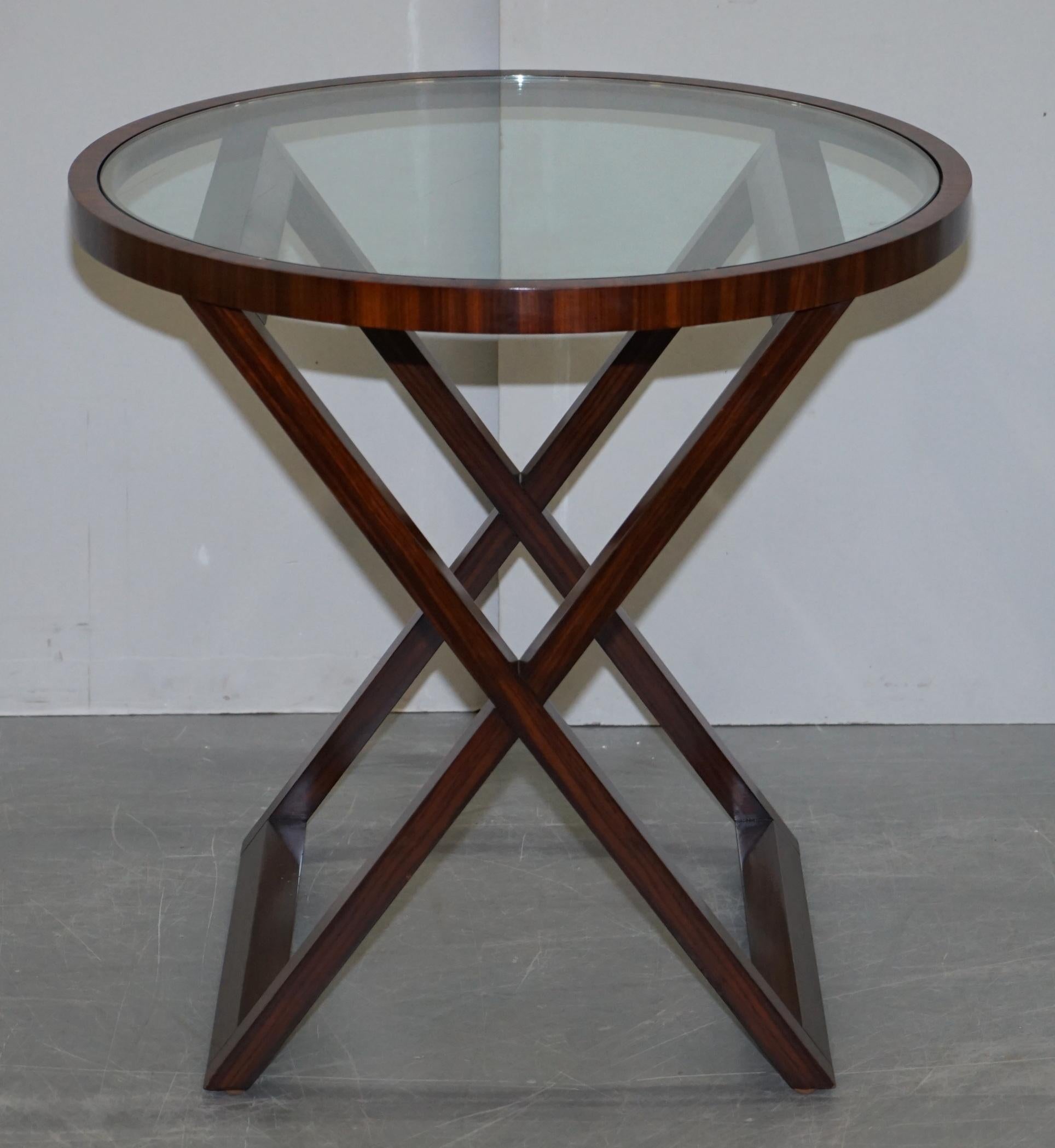 We are delighted to offer this exquisite Ralph Lauren American Mahogany X framed round occasional side table

A beautiful example of Ralph Laurens premium furniture range, the glass top makes a perfect lamp table as the light filters all the way