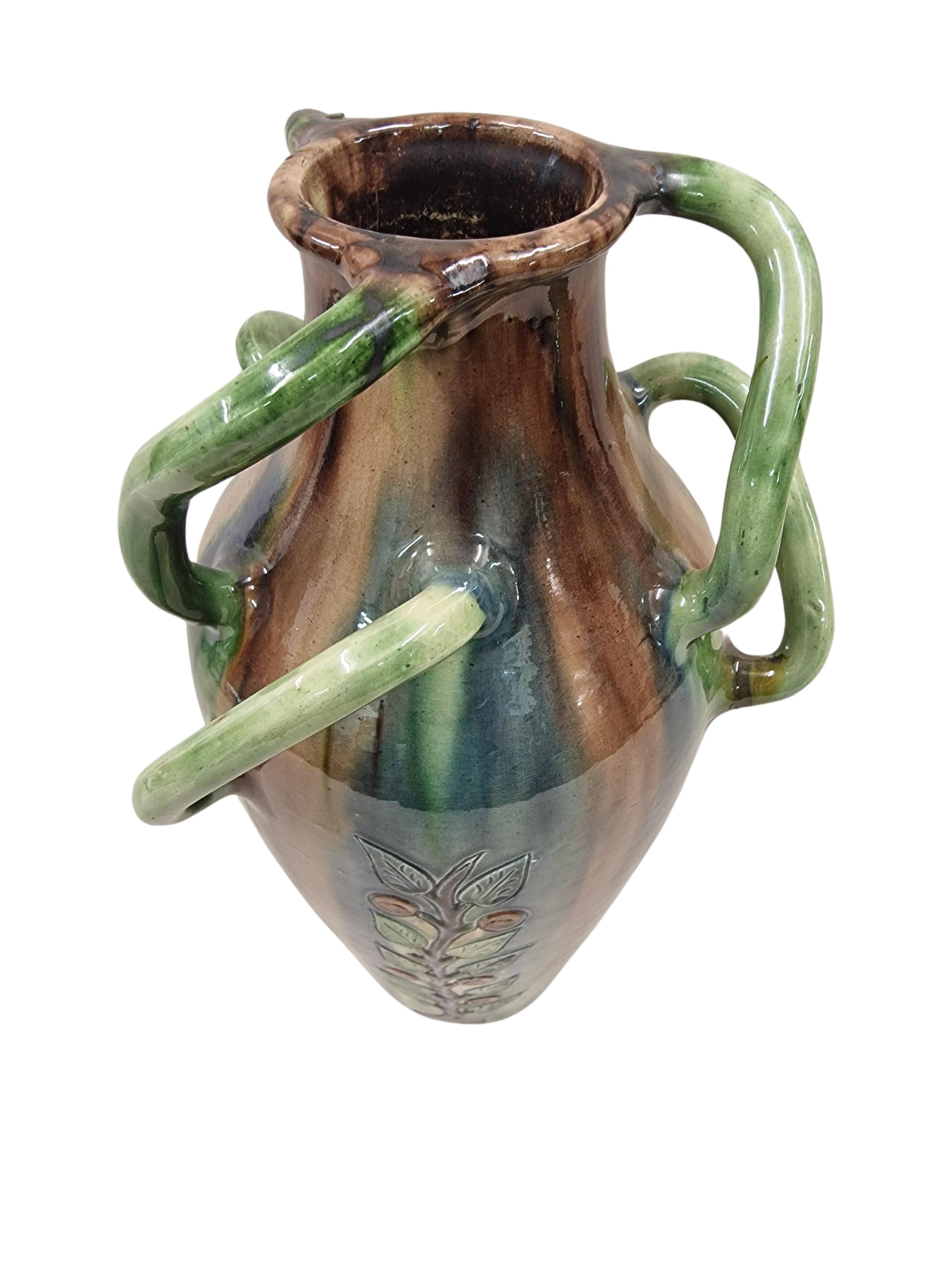 Stunning flower vase, ceramic, made in the Art Nouveau period around 1910 in Belgium. 

This beautiful unusual vase is designed with an exquisite running glaze, and three vertical stylized flower tendrils are cut around the vase.
What is