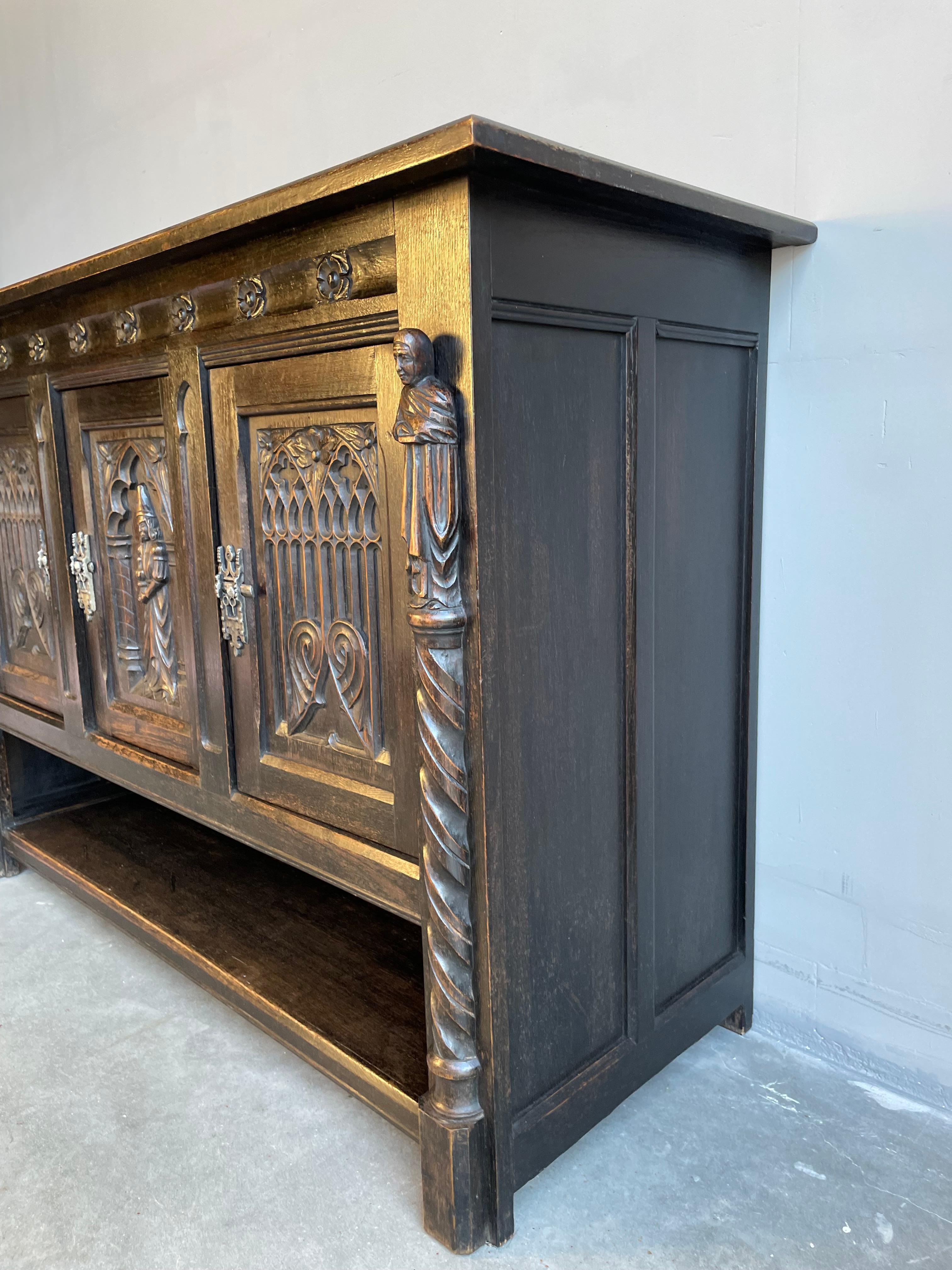 Early 1900s, solid oak, and very rare Gothic cabinet.

This beautifully and deeply carved oak sideboard from the early 1900s is in amazing condition. We have owned and sold our fair share of antique Gothic furniture, but never before have we seen an
