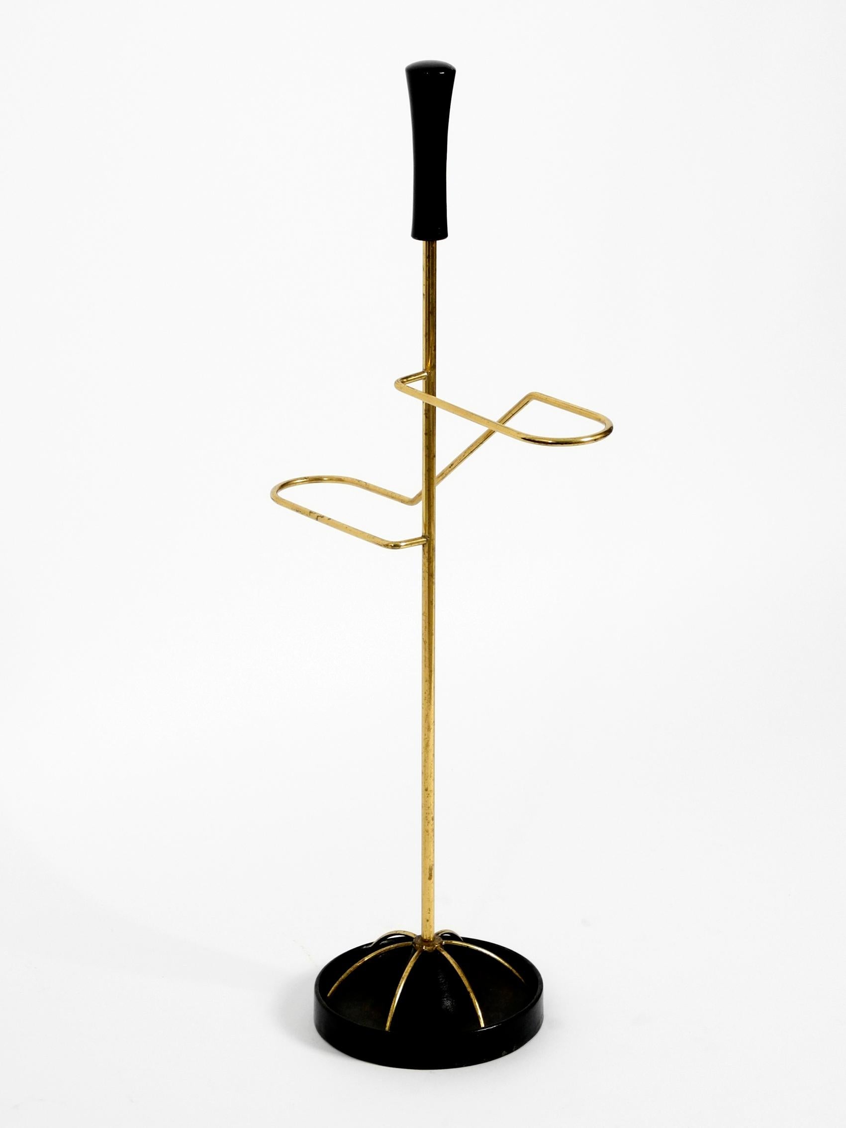 Very elegant extraordinary Mid-Century Modern umbrella stand made of brass and with a cast iron base. Minimalist high quality design with brass frame and cast iron base in black. Made in Austria. Very good condition without damages and with minimal