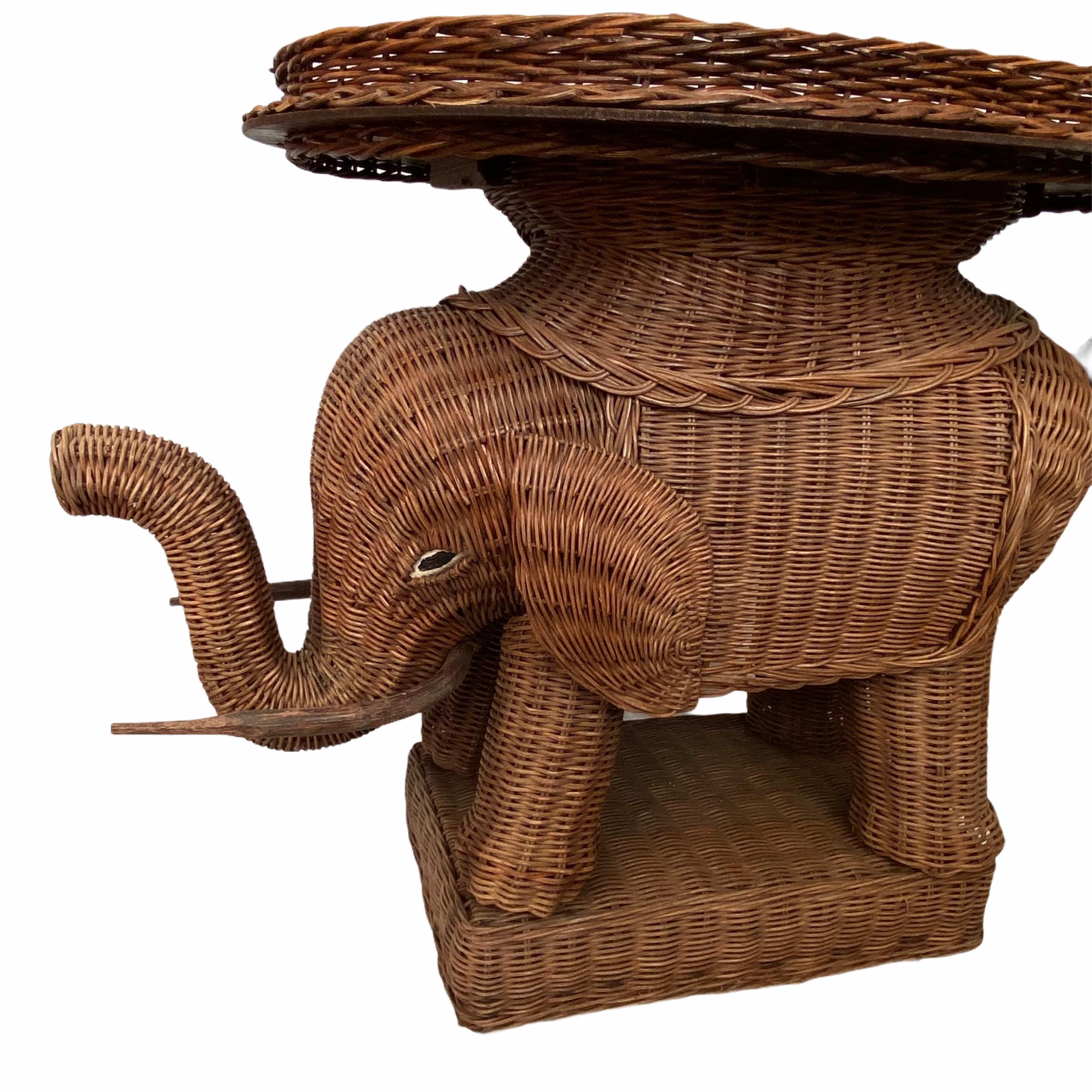 Mid-20th century eye-catching elephant-shaped end table or side table, constructed in hand-braided rattan accented with wood tusks. Nice addition to your home, patio or garden. This is in used condition, with signs of wear as expected with age and