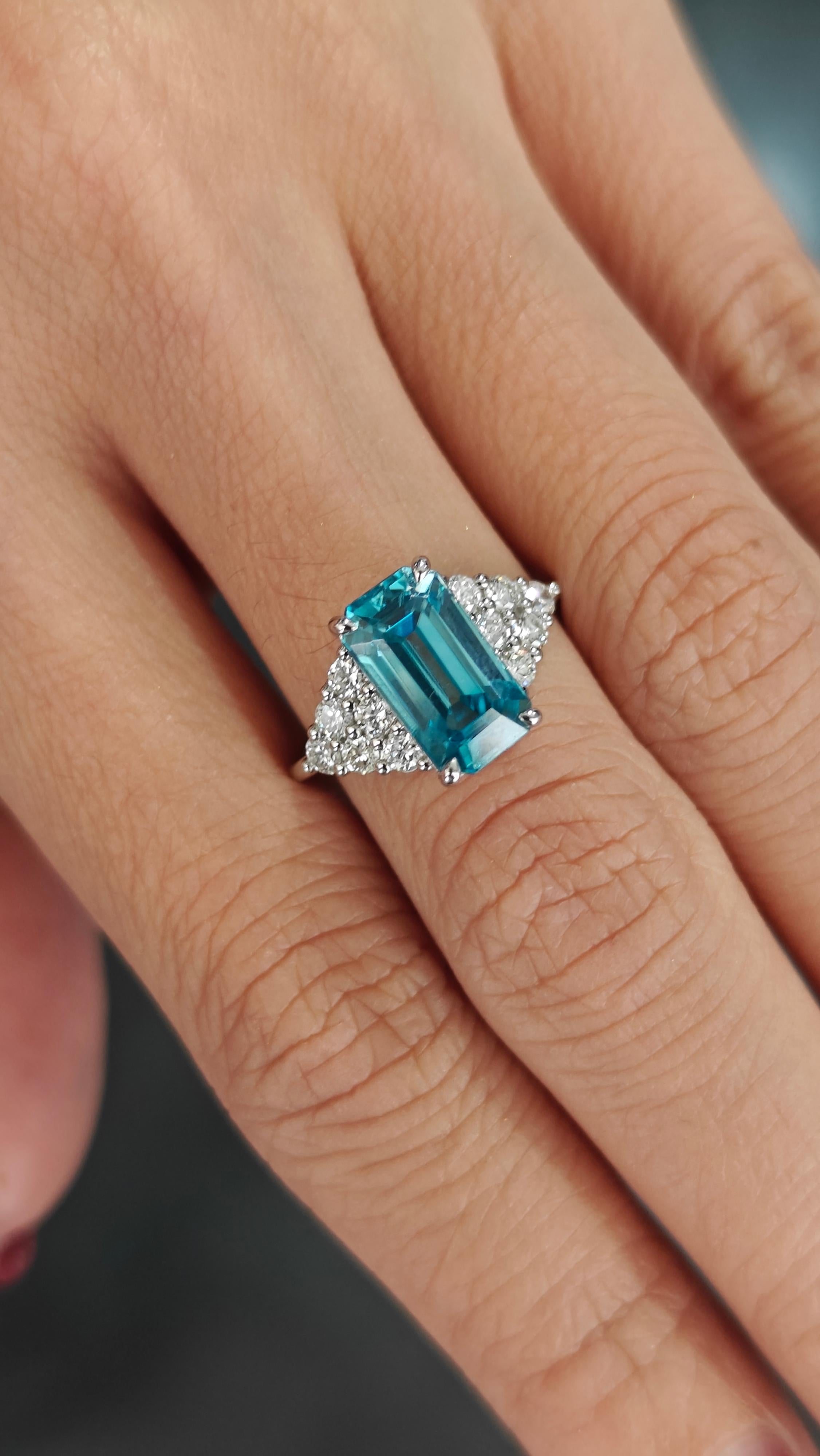 Showcasing breathtaking elegance, this platinum ring is a stunning blend of vintage charm and contemporary style. At the heart of the design lies an impressive natural blue zircon in a vibrant emerald-cut, radiating a captivating blue hue