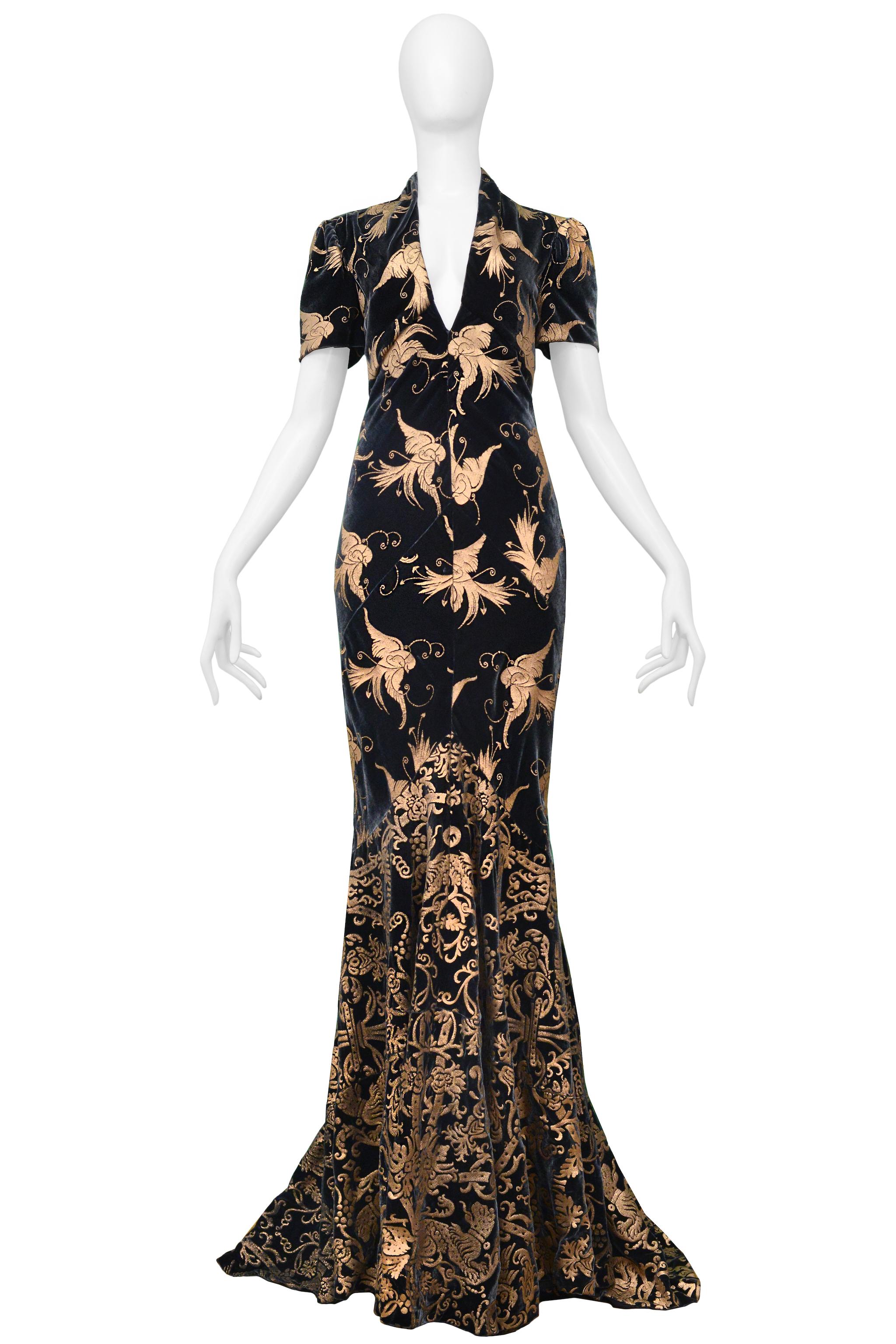 Resurrection Vintage is excited to present a vintage Roberto Cavalli green velvet evening gown featuring a metallic gold bird print, deep V neckline, exposed back cutout, button collar, short sleeves, center back zipper, and dramatic gown length