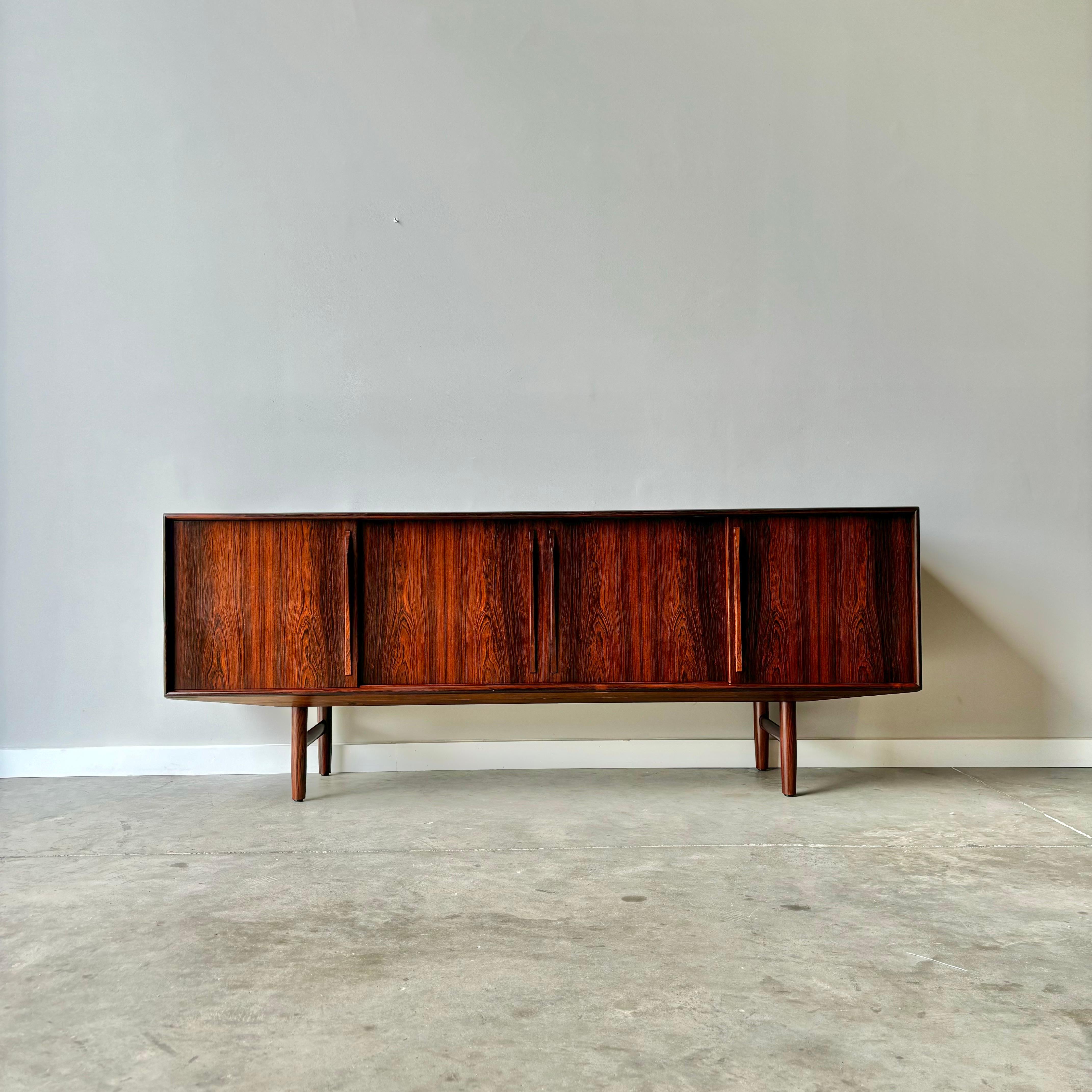 A stunning 1960s rosewood credenza by Danish designer Kurt Ostervig.  Purchased from the iconic Illums Bolighus in Copenhagen, Denmark.  
A large storage piece with sliding doors and plenty of storage.  Rosewood front drawers in one compartment and