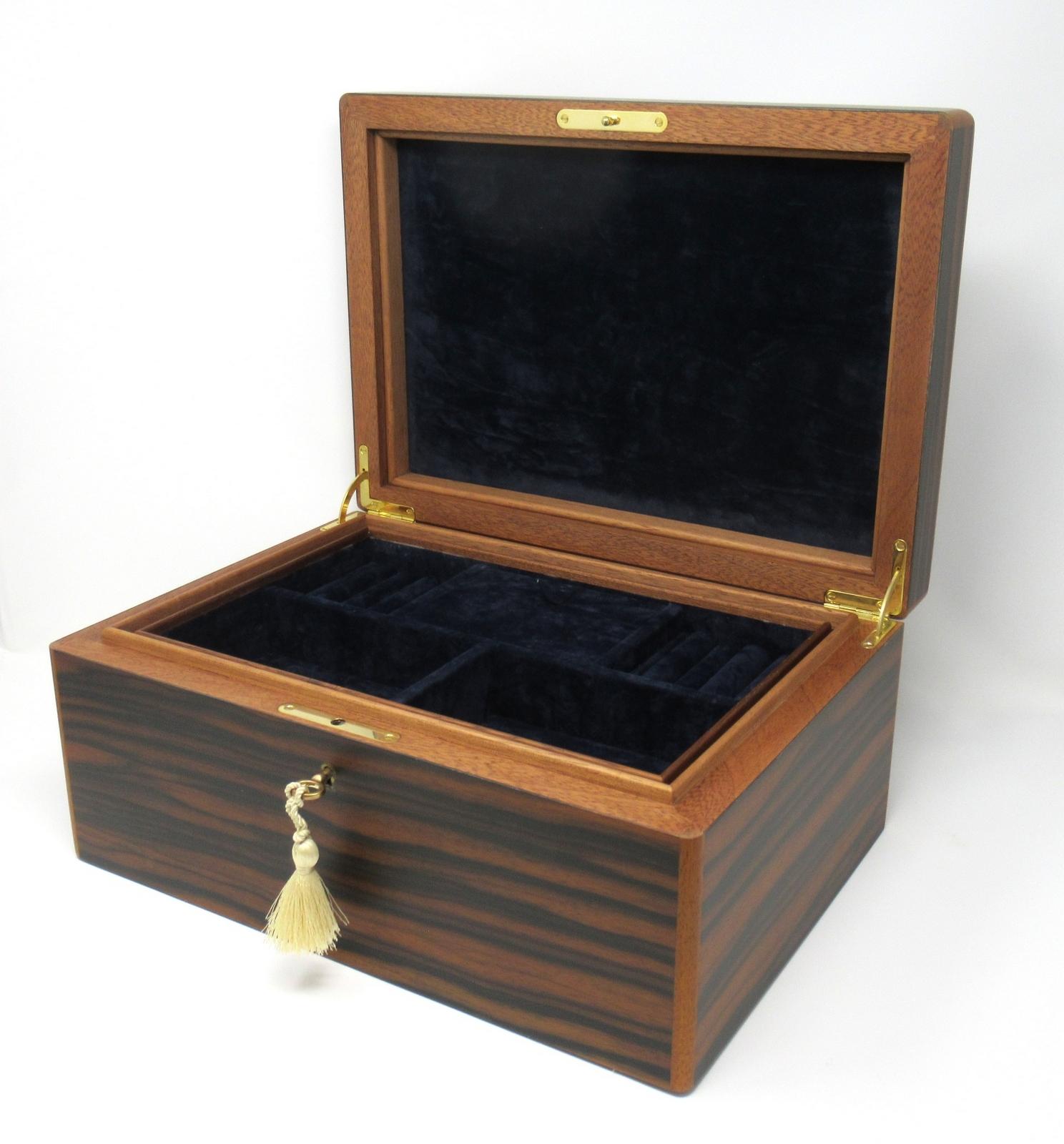 Stunning Well Figured Mahogany Ladies or gentleman's jewelery box casket made by manning of Ireland of generous proportions, with interior and lift out tray lined in luxury dark navy blue velvet lining. Finest quality superior gold-plated hinges,