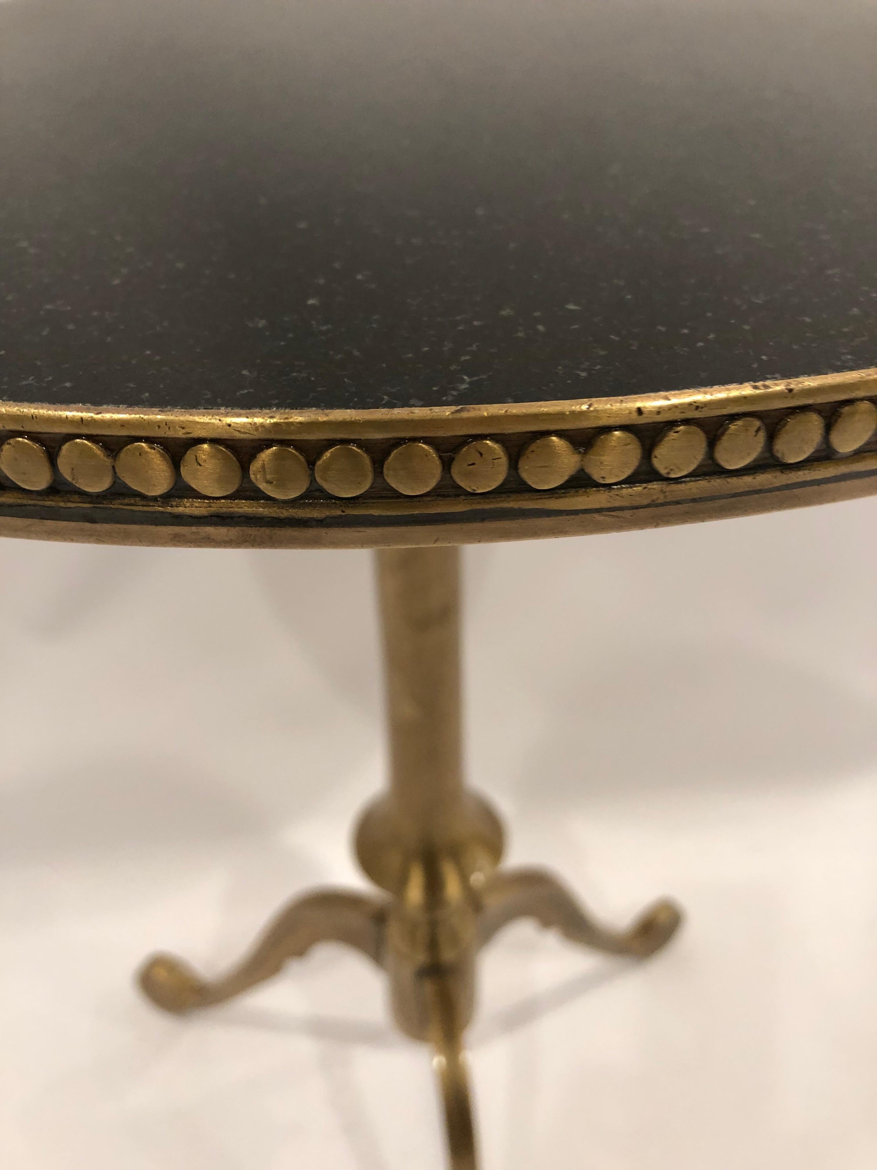 Great looking round antiqued brass and black granite drinks table having tripod legs and adjustable column.