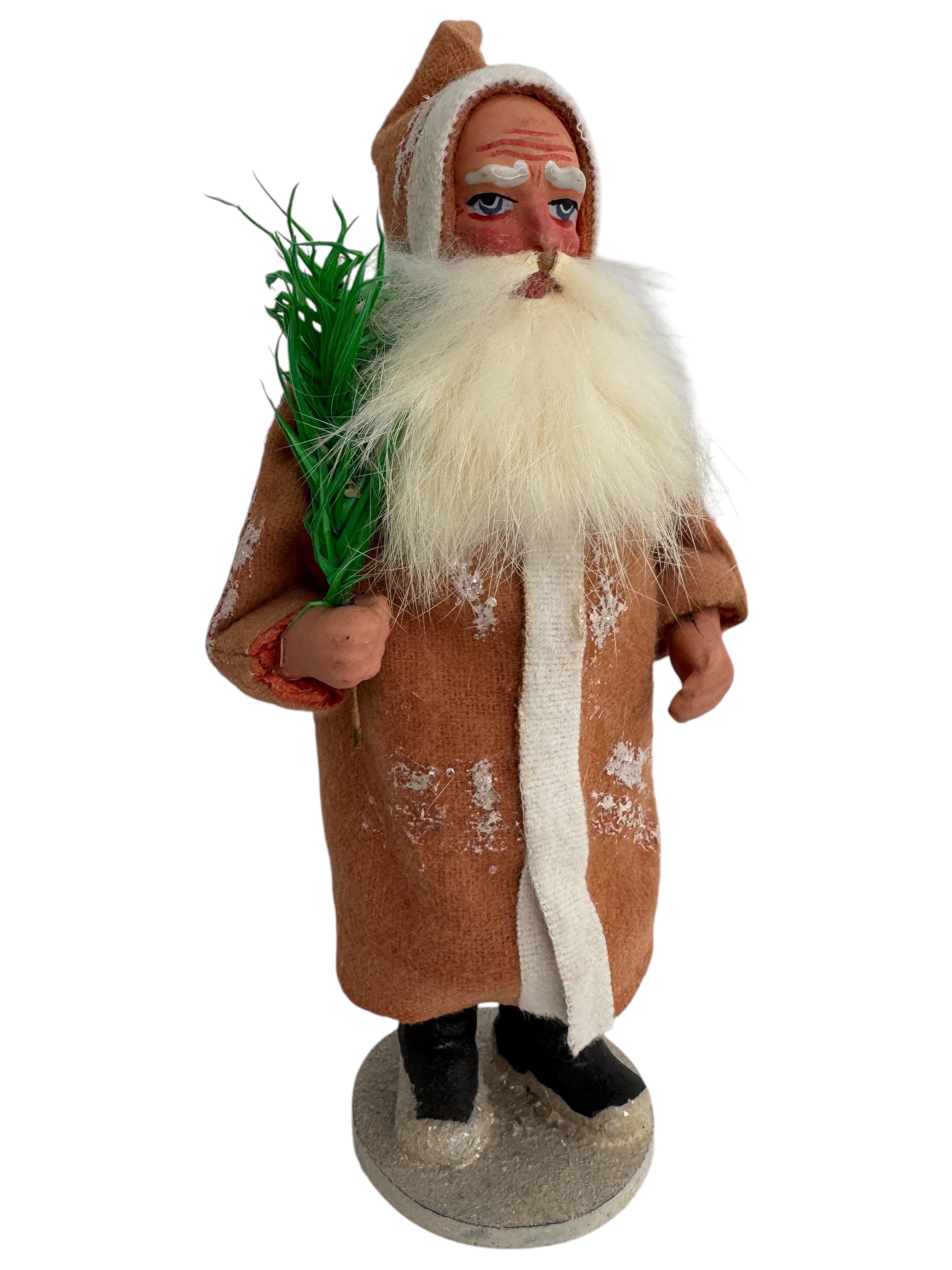 Este antiguo recipiente para caramelos de Papá Noel hecho de papel maché, composición, cartón, fieltro, árbol de plumas de ganso y barba de piel de conejo se fabricó a principios del siglo XX, hacia la década de 1910, y es un complemento encantador