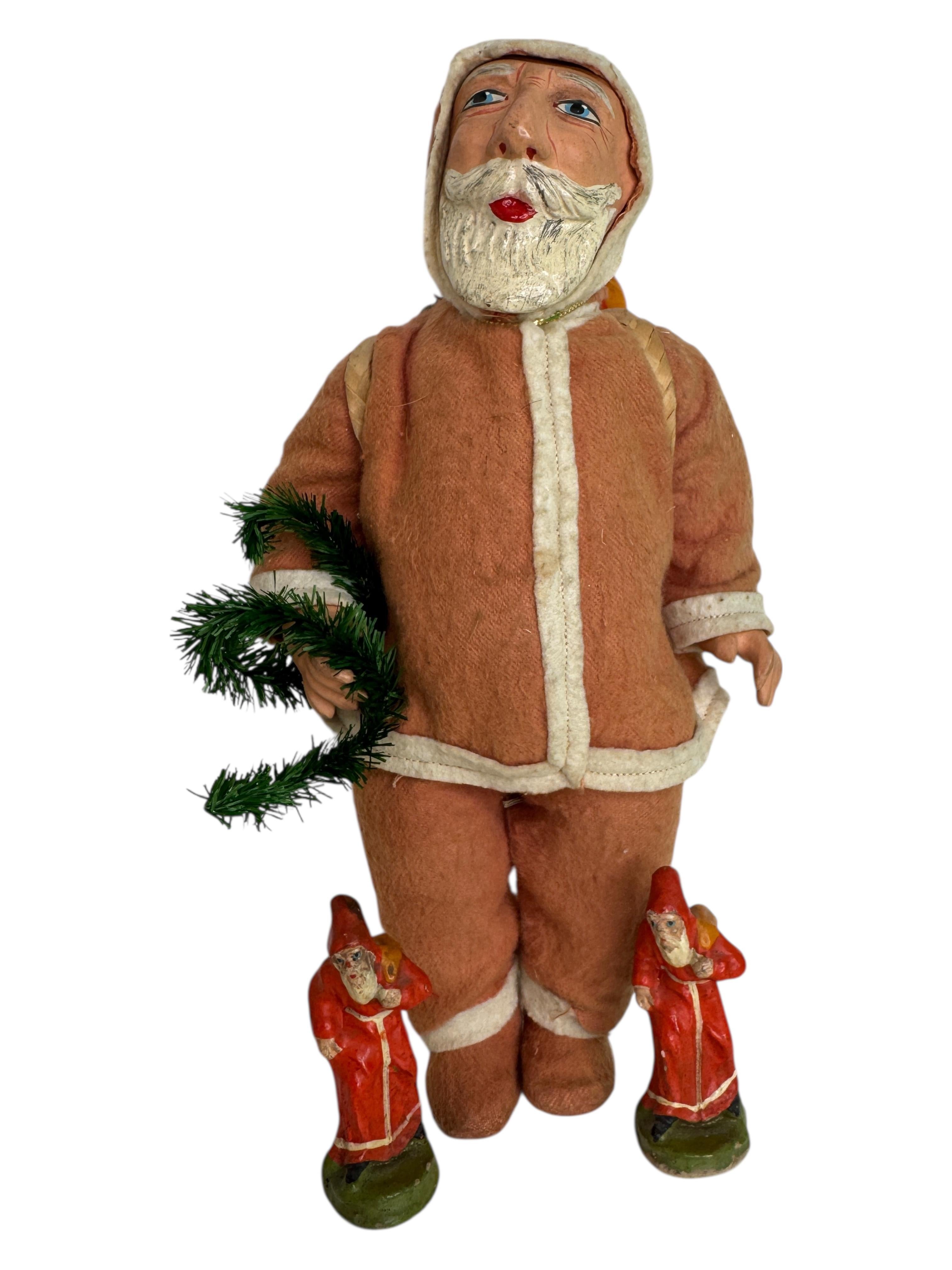 Cette poupée antique de décoration de Noël du Père Noël est faite de Collectional, de papier mâché, de feutre, d'un arbre et d'autres matériaux. Elle a été fabriquée au début des années 1920 et constitue un ajout charmant à toute collection de Noël.