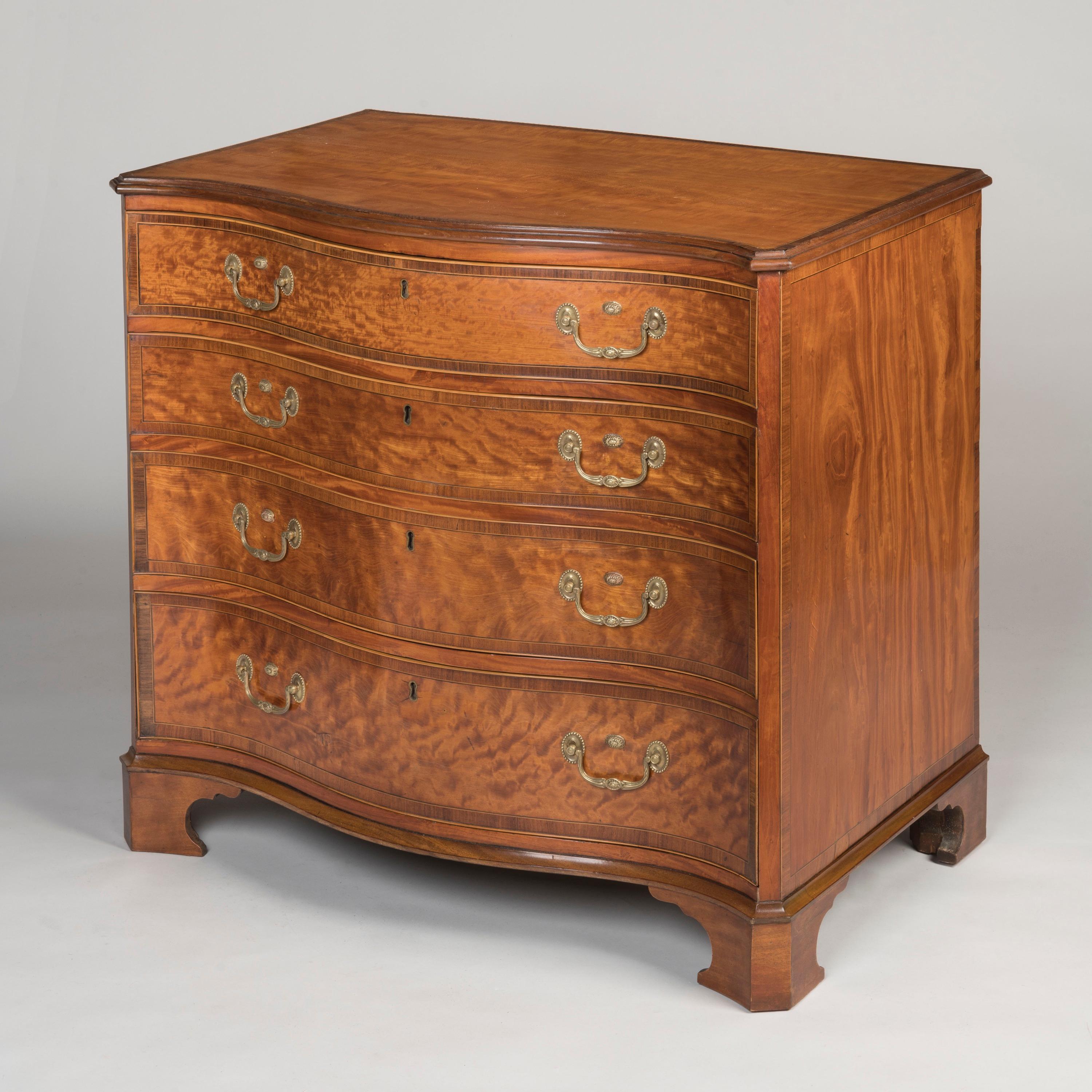 A Fine Satinwood Serpentine Chest of Drawers
Of the George III Period

Constructed in satinwood with rosewood crossbanding, the serpentine chest rising from bracket feet, housing four cock beaded graduated drawers with ebony and boxwood stringing,