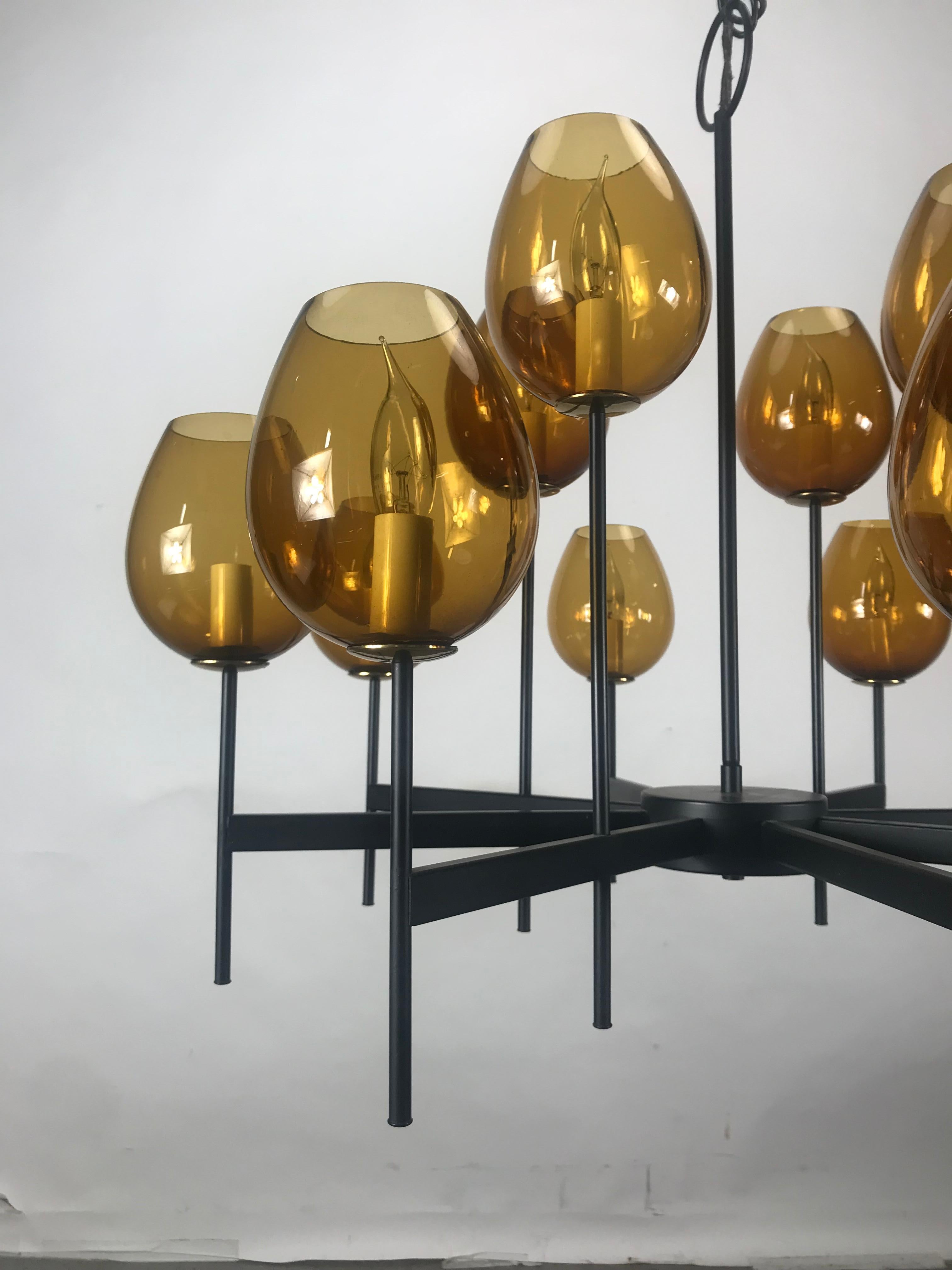 Scandinavian blown glass globes and iron chandelier, 12 amber blown glass globes, Architecturally designed iron frame, Up to 49