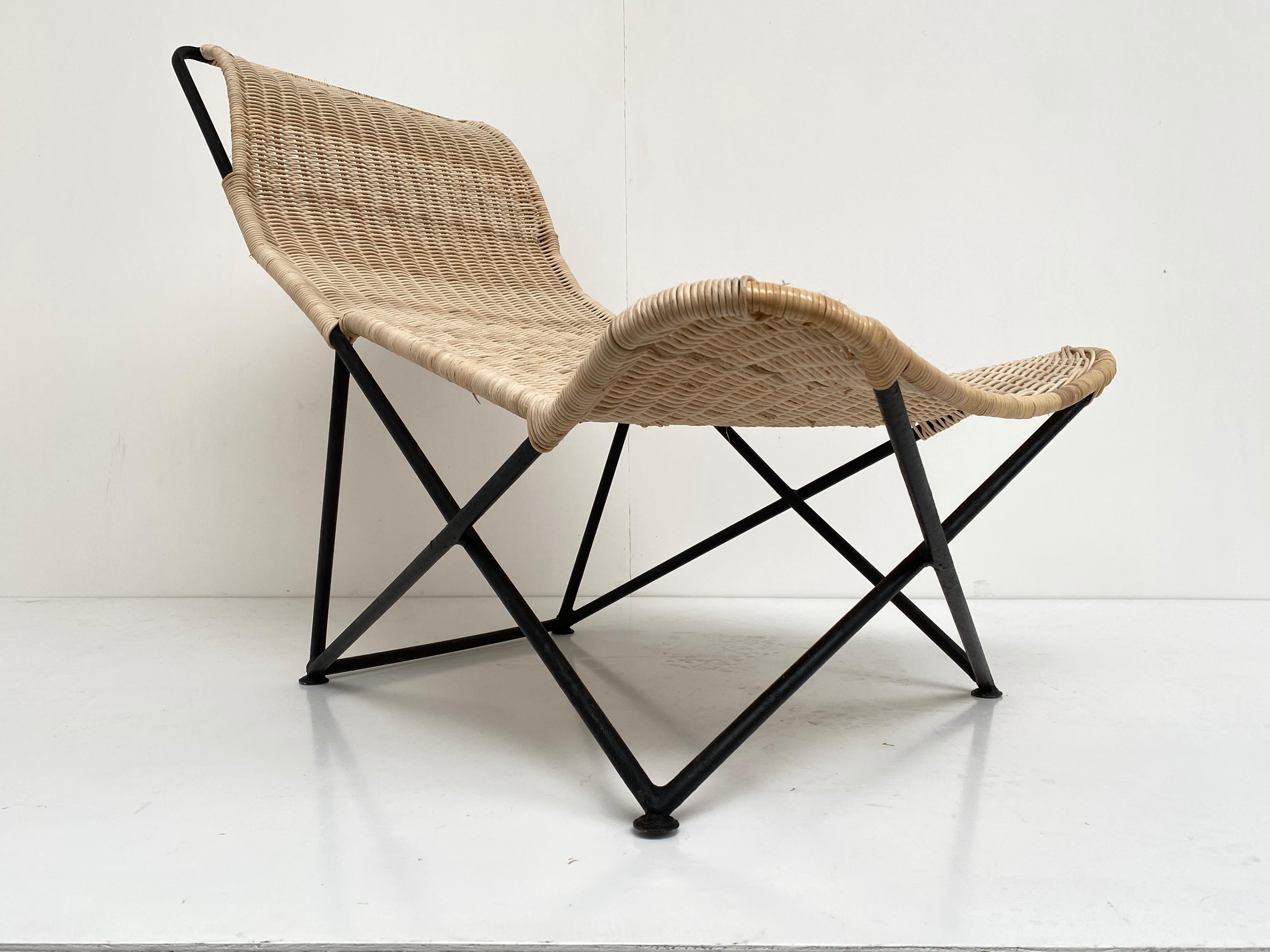 Stunning French 1950s sculptural form wicker chaise. This chaise has the wonderful juxtaposition of a free form organic flowing organic wicker element mounted on a Minimalist triangulated enameled steel frame adding to the overall lightness and