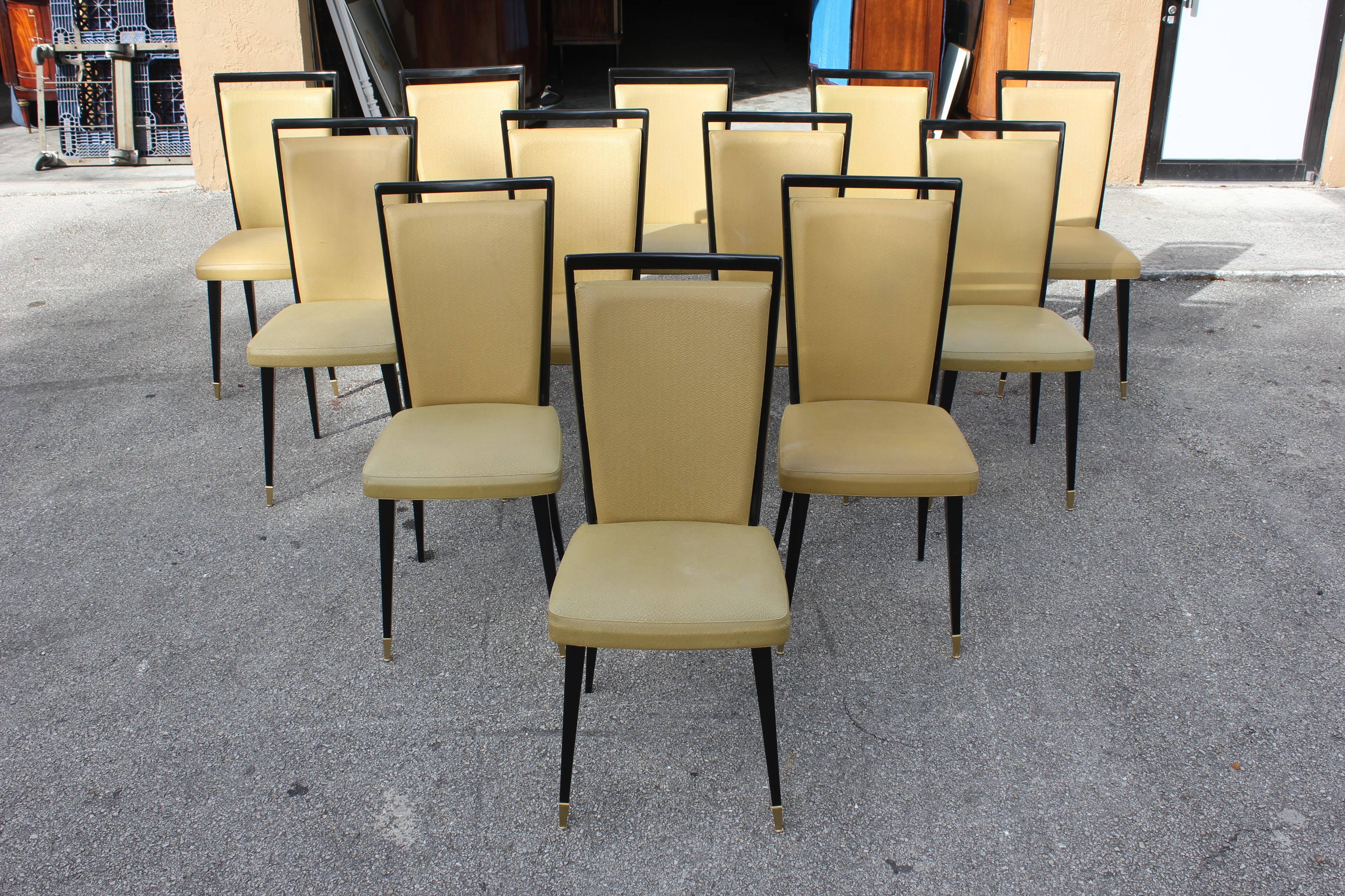 Stunning set of 12 French dining chairs with frames made of solid mahogany that have been ebonized and finished with a French polish Gloss, the two front feet are capped with brass ,the chair frames are in excellent condition (Reupholstery