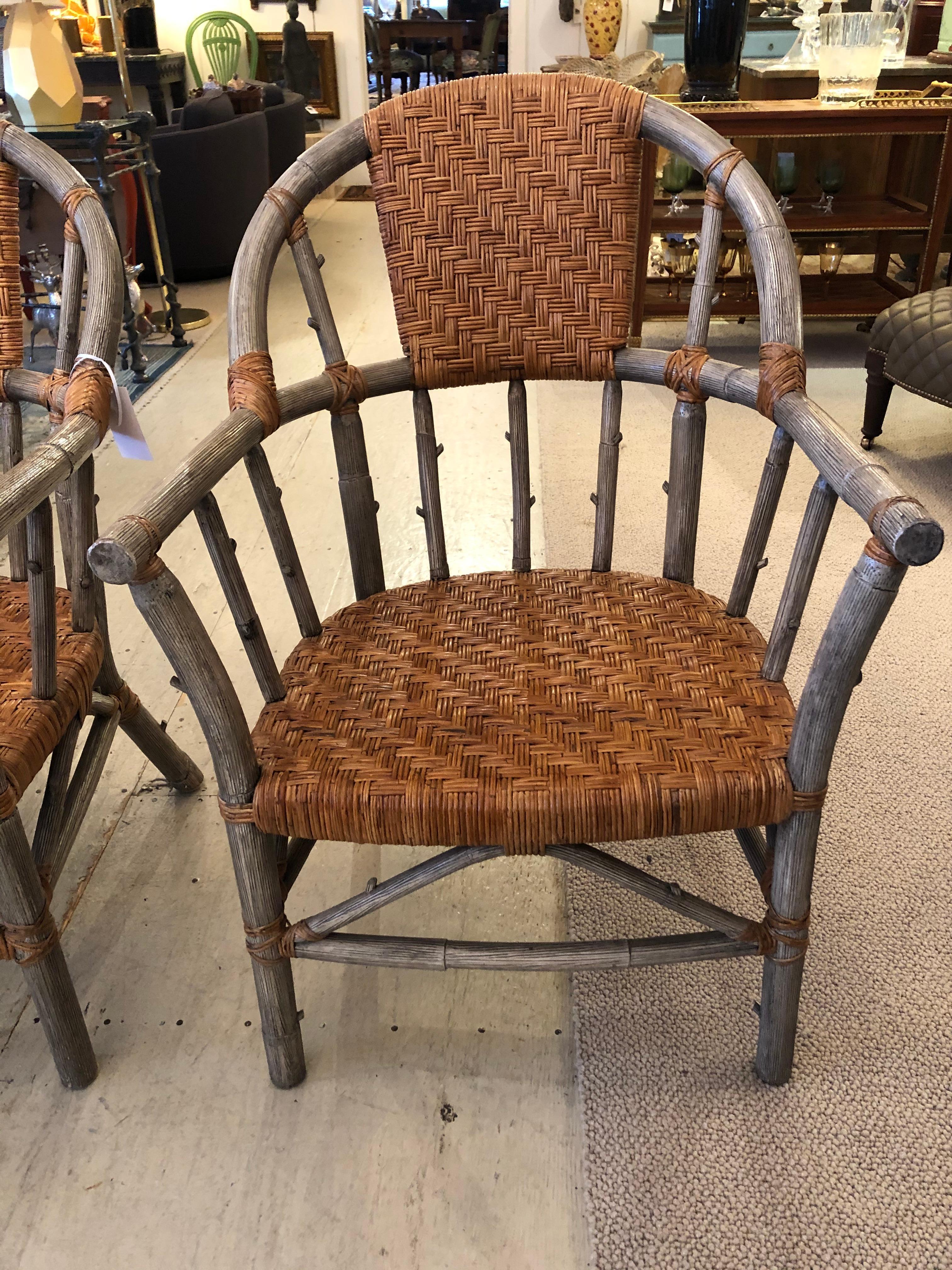 A handsome set of 4 armchairs, great for around a dining table or as living room chairs. The body of the chairs is a grey faux bois with contrasting tan woven rattan seats, back and decorative laces artfully accenting the joints.
Measure: Arm