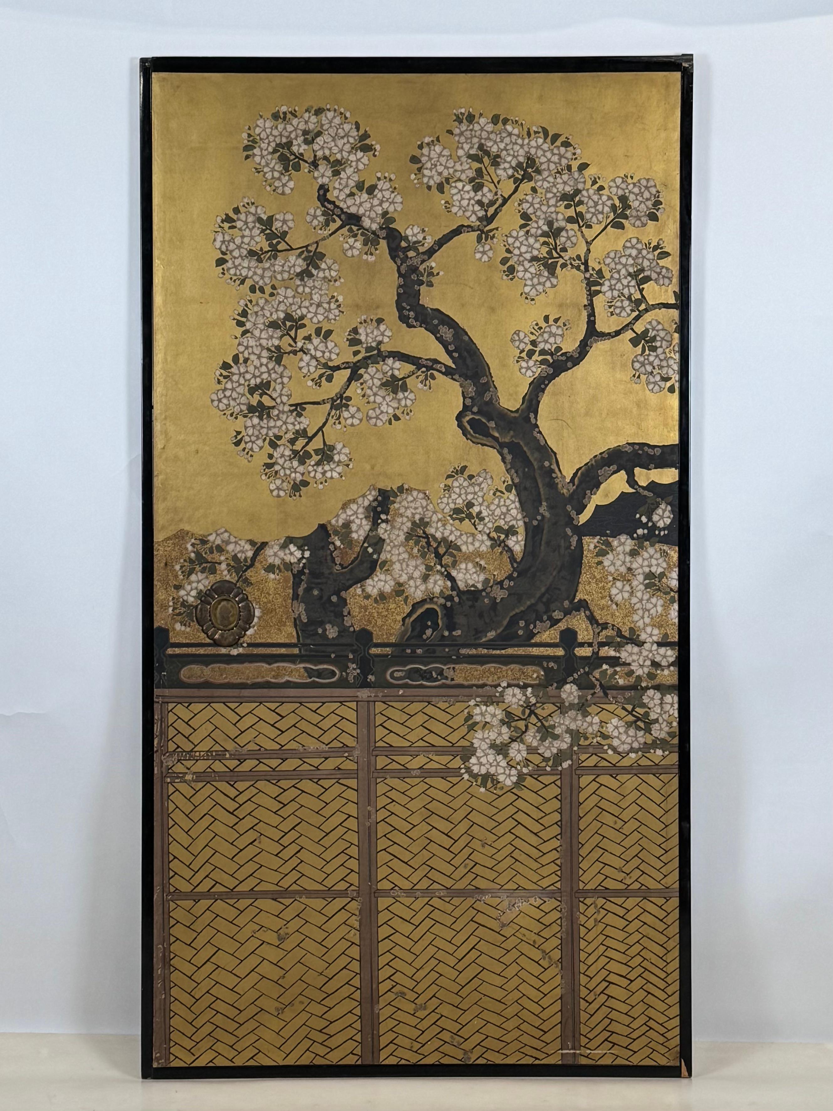 A set of four fusuma (sliding door) panels from the 19th century, painted in ink and colors on gold leaf. The panels depict a blossoming cherry tree extending beyond a woven fence and over a pond with ducks, mallards, and cranes. Reeds line the