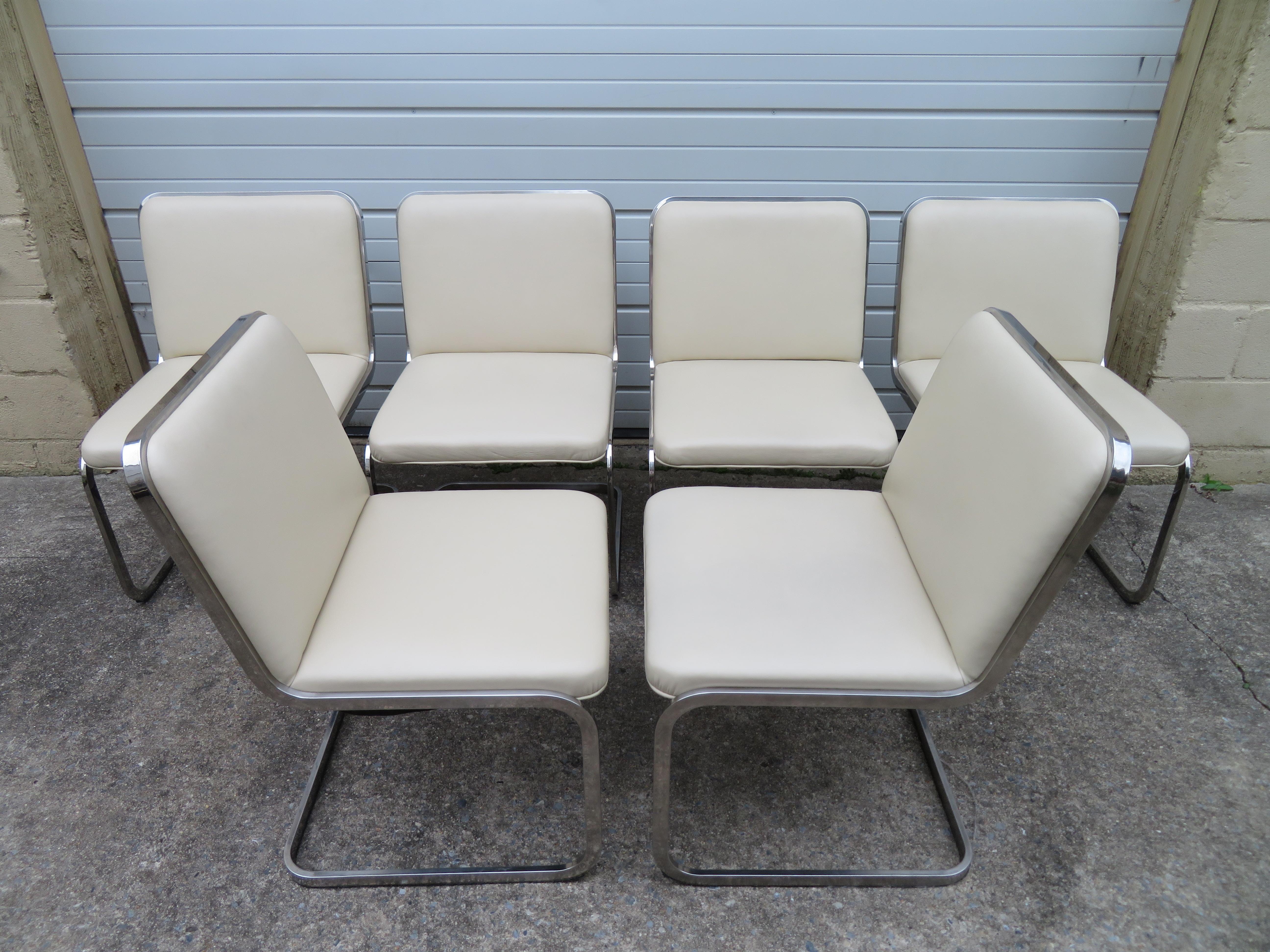 Stunning set of six Brueton flat band chrome cantilevered dining chairs with cream colored Faux leather upholstered seats and back. Very nice, clean, original condition. We love the simple cantilevered design along with the high quality