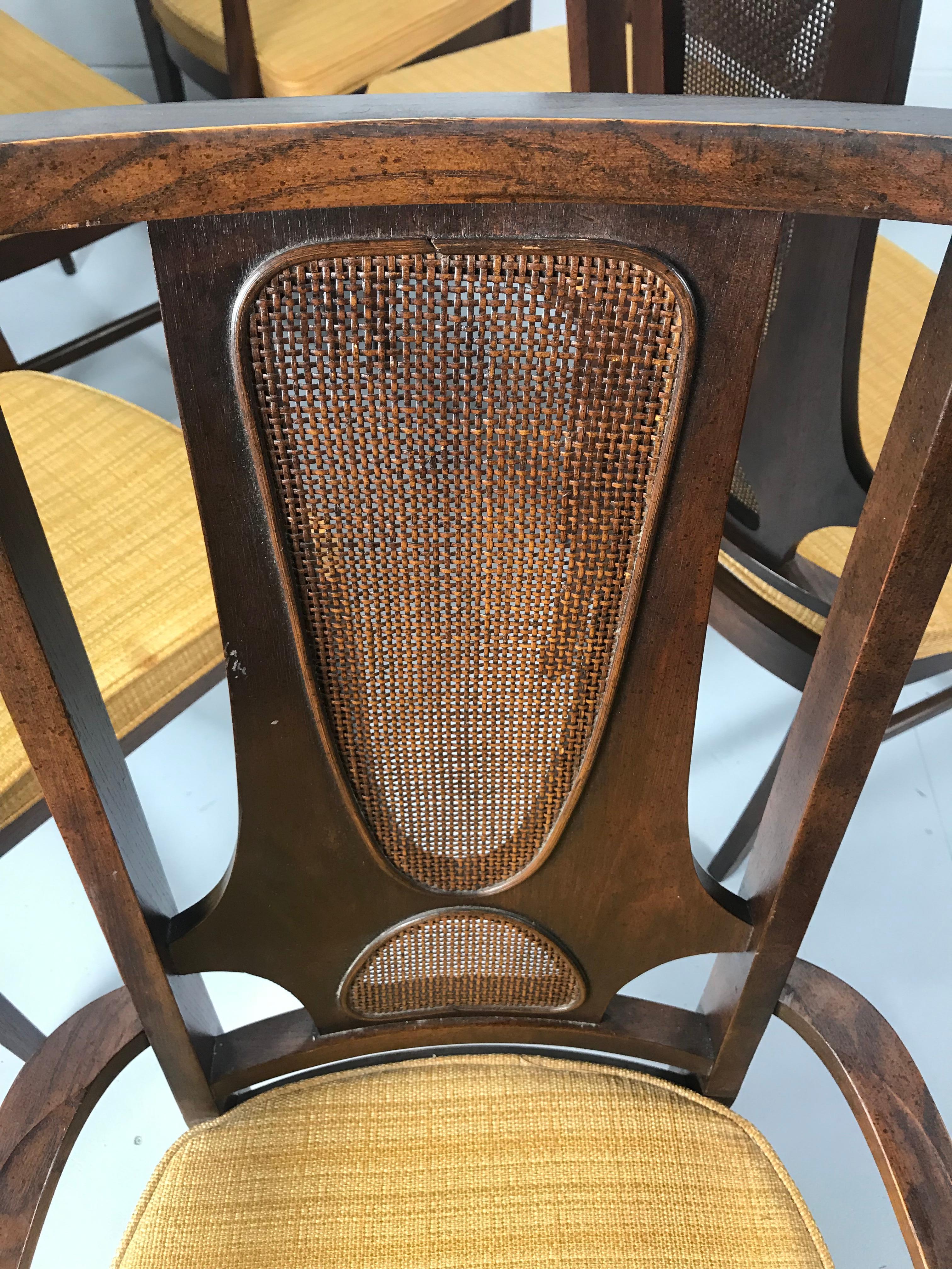 Set of six vintage walnut dining chairs manufactured by Broyhill for the Brasilia collection circa early 1960s. Seldom seen version with original caning. An extremely desirable example of midcentury American furniture design. The chairs feature