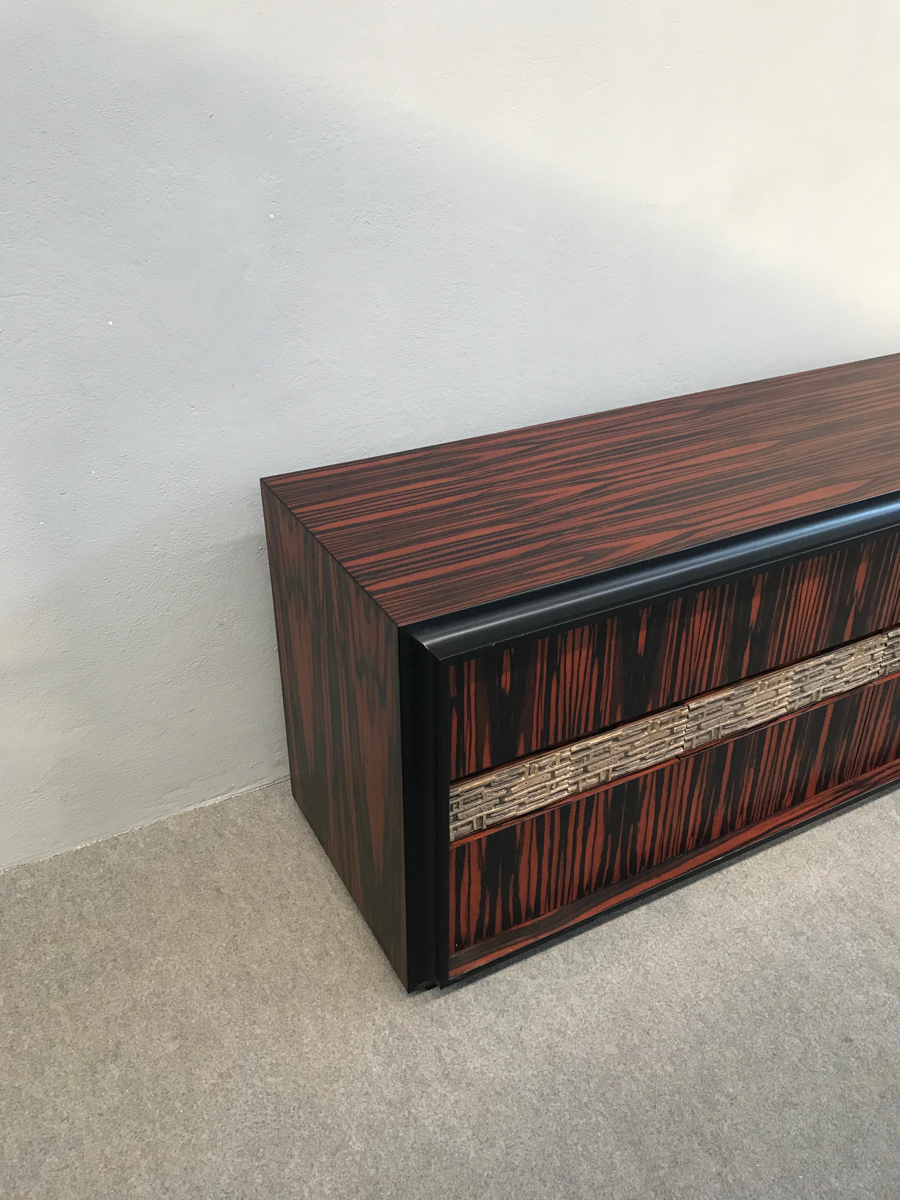 Sideboard designed by Luciano Frigerio, four doors with drawers and shelves.
Bronze sculpture in the front.