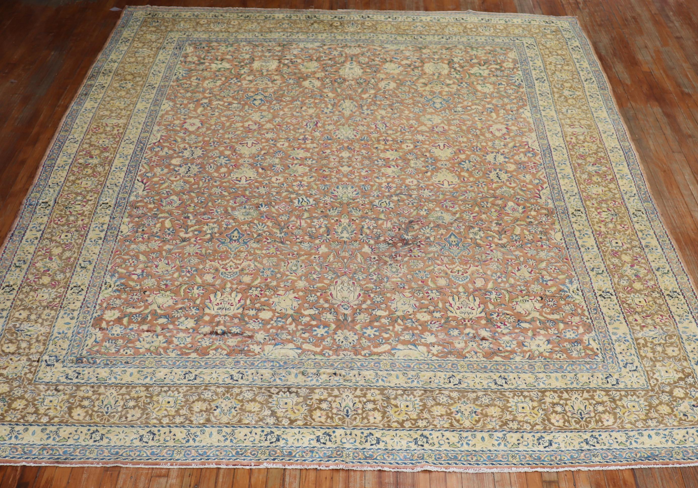 An early 20th century North Indian Kerman rug woven with silk sheen wool. Sparkling accents in pink, blue and raspberry on a brown colored field.

Measures: 10'7'' x 13'6''

Unlike antique Agra carpets manufactured in the prisons of India,