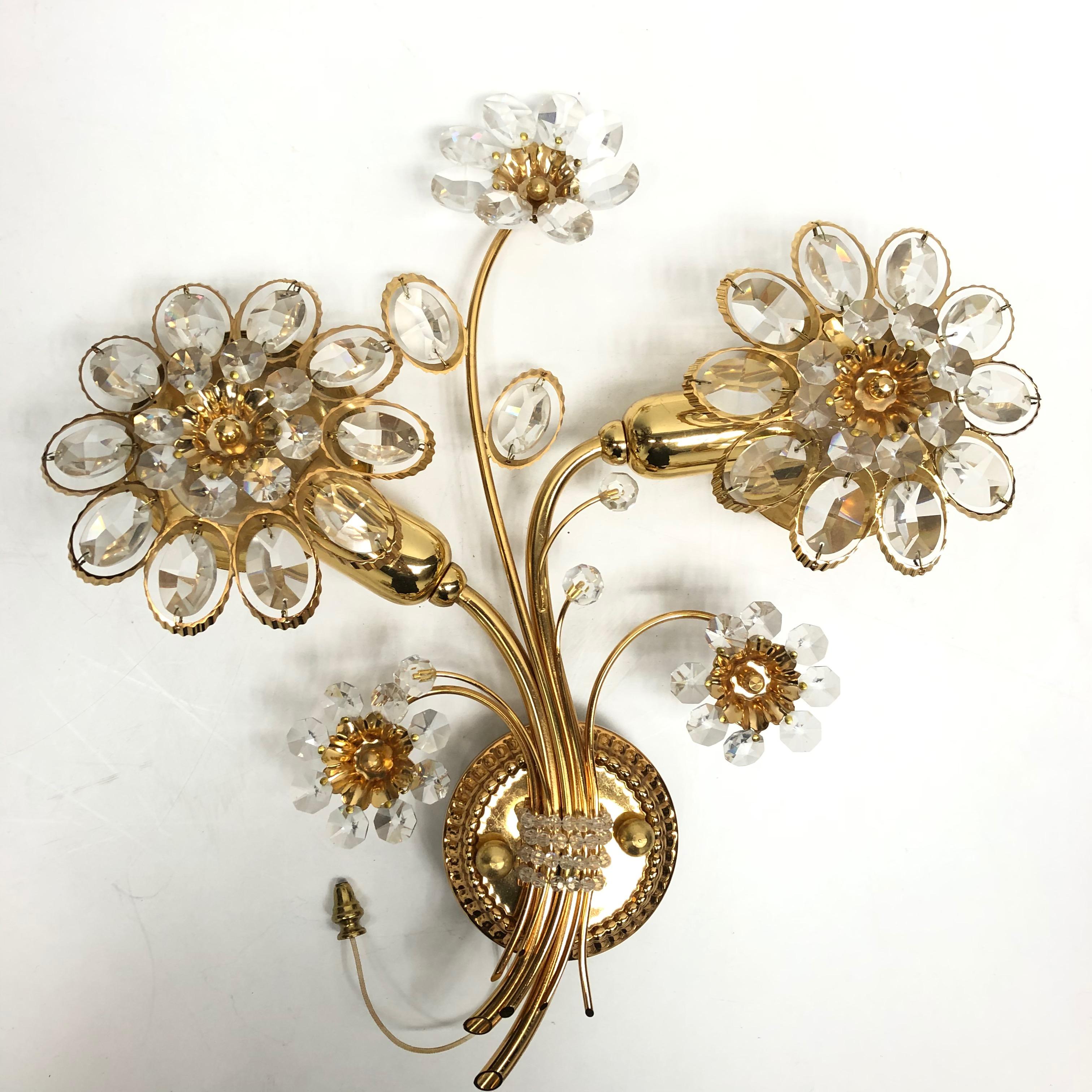 A single vintage gold-plated sconce with faceted crystal flowers made by the German company Palwa. The fixture has two European style E14 sockets. It requires European E14 candelabra bulbs, up to 40 Watts each.