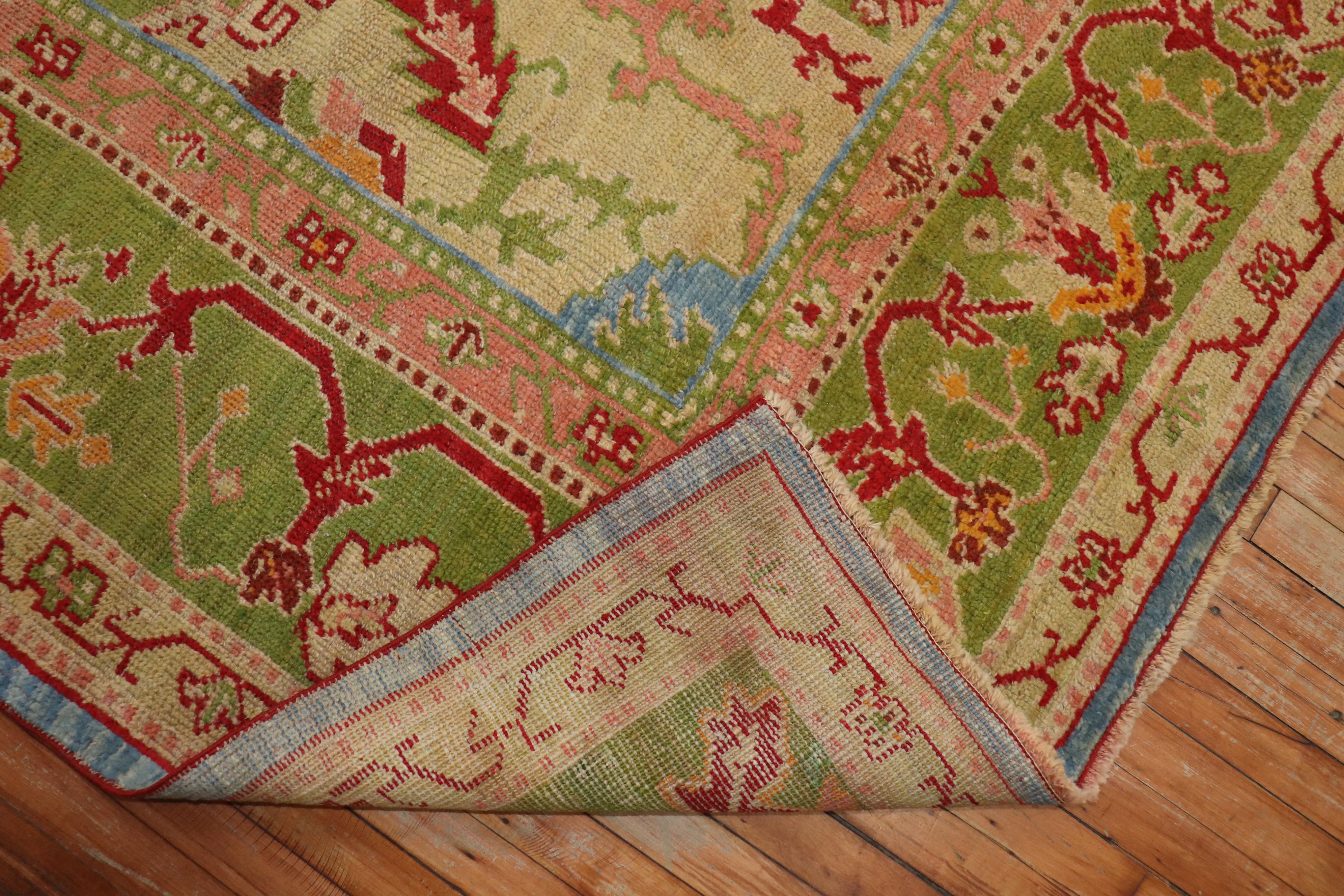An early 20th century antique Turkish Oushak carpet with a sky blue field, border, and center medallion in apple green.

Measures: 11'4'' x 15'.