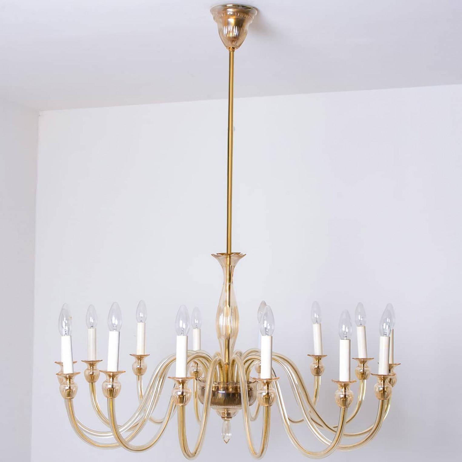 Bellissimo lampadario a 14 bracci in vetro di Murano soffiato a mano, Italia 1960.

Il caldo vetro ambrato emana una luce ricca e invitante, mentre l'elegante design e la lavorazione artigianale lo rendono un punto focale in qualsiasi stanza.