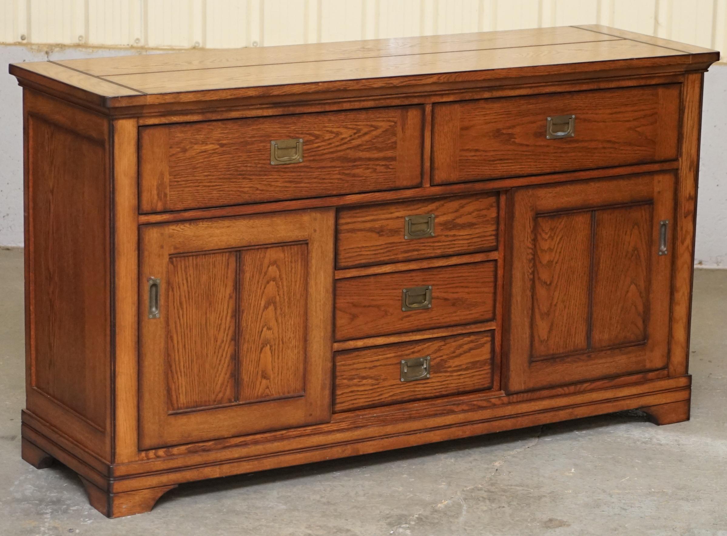 We are delighted to offer for sale this stunning solid oak Campaign style sideboard with drawers and cupboard 

A very good looking well made and substantial piece of furniture, its very solid and well made, its quite utilitarian and can be used