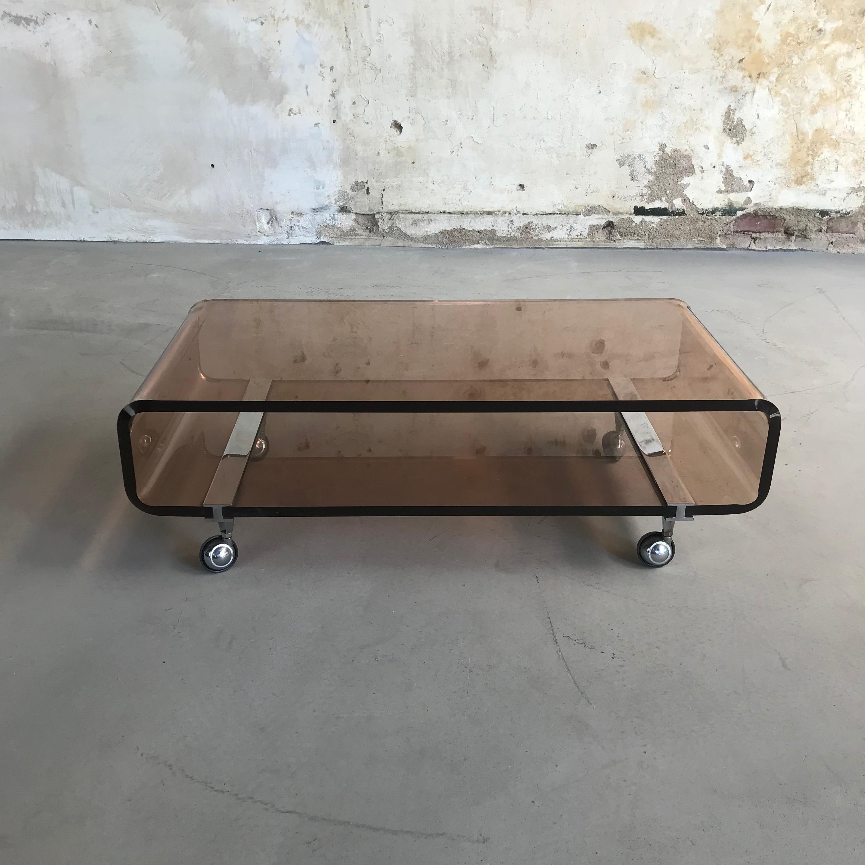 Schöner und seltener Couchtisch oder Beistelltisch, entworfen von Michel Dumas für Roche Bobois in den 1970er Jahren.
Dieser Blickfang ist aus extra dickem, hochwertigem, moduliertem, bernsteinfarbenem Plexiglas (Altuglas) mit verchromten