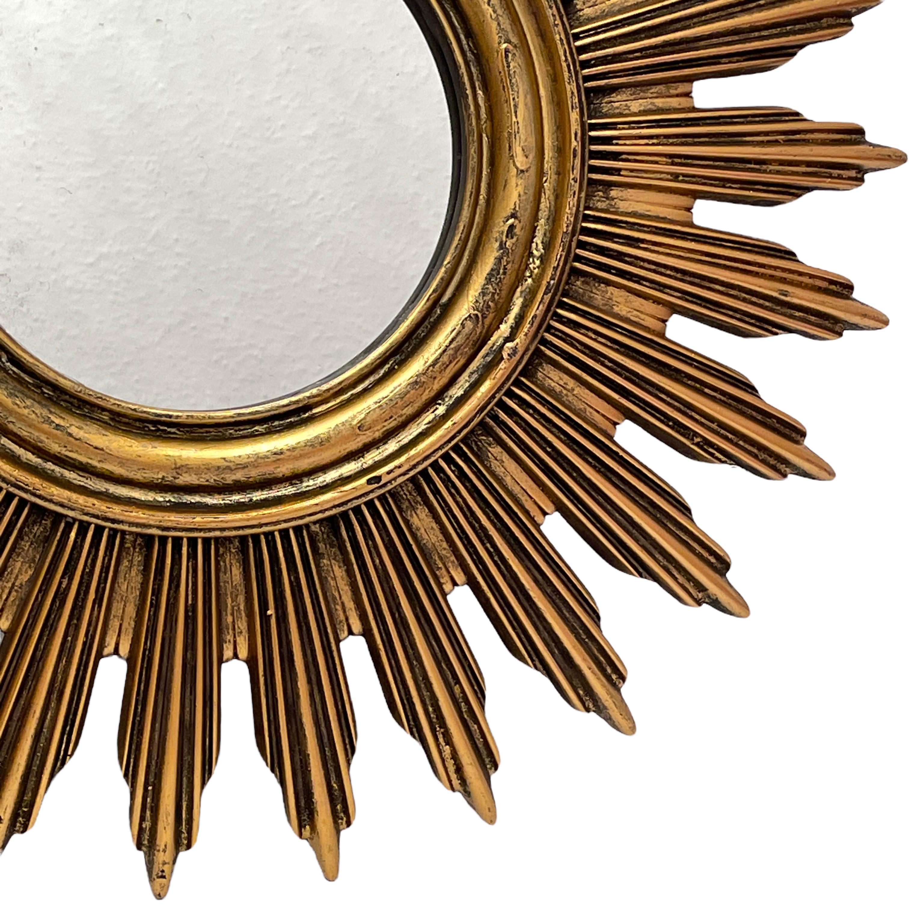 A beautiful starburst sunburst mirror. Made of gilded resin and wood. It measures approximate 20 3/8