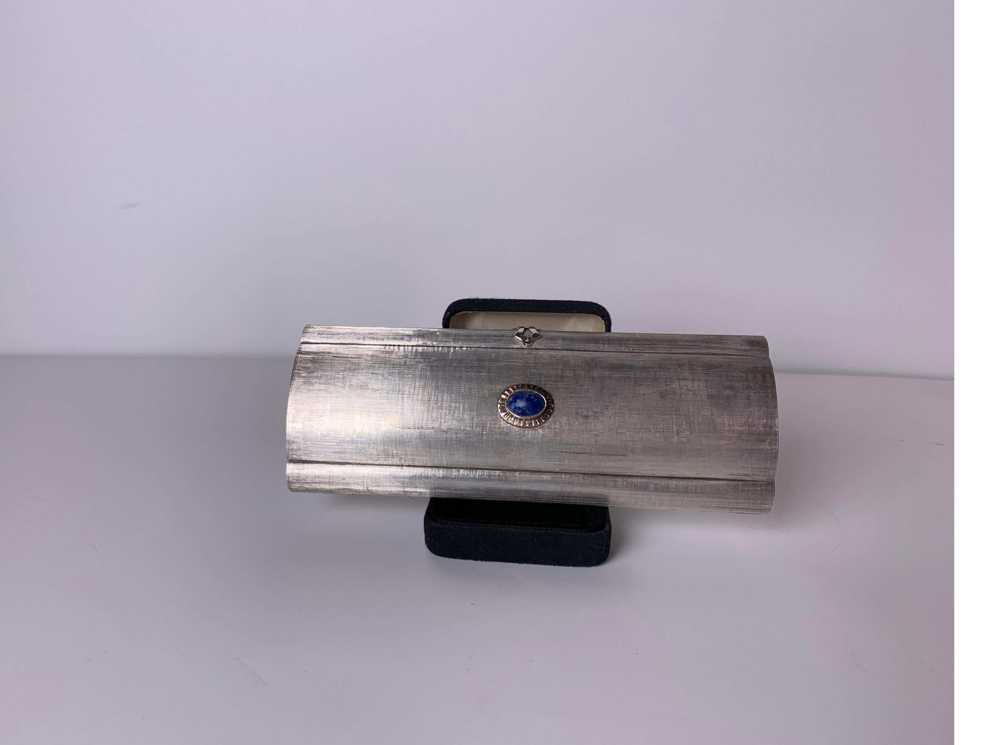 Rare and unusual high style sterling silver evening clutch with lapis. The interior is fitted with a mirror and compartments for cosmetics. The surface is a burnished satin solid sterling silver. Overall very good condition with some light spotting