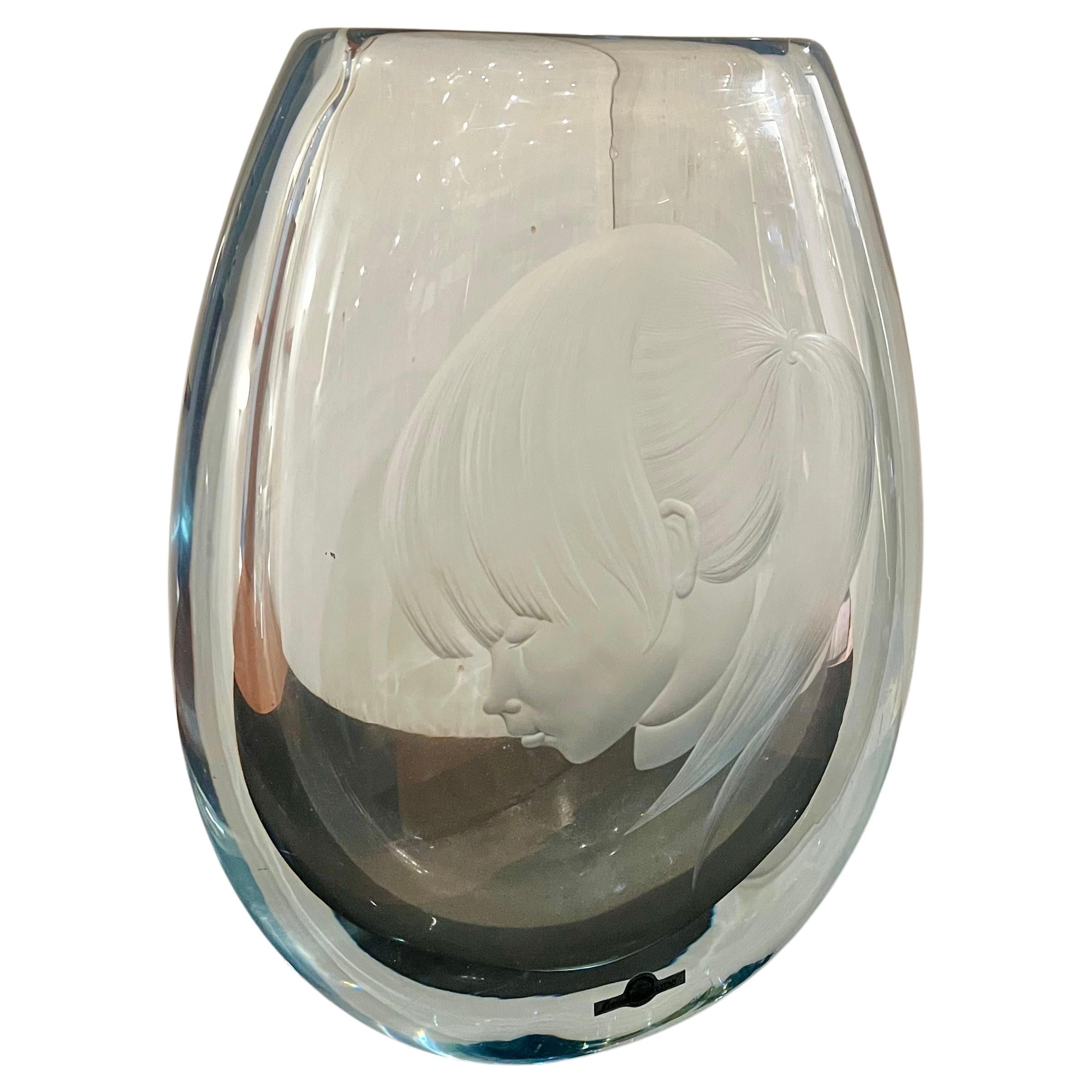 A masterful execution in this beautiful and large piece of Swedish art glass from Strombergshyttan Glass Company. On the front side is a beautiful girl's face, The glass has Stromberg's distinctive silver-blue tint. retains label and it's signed at