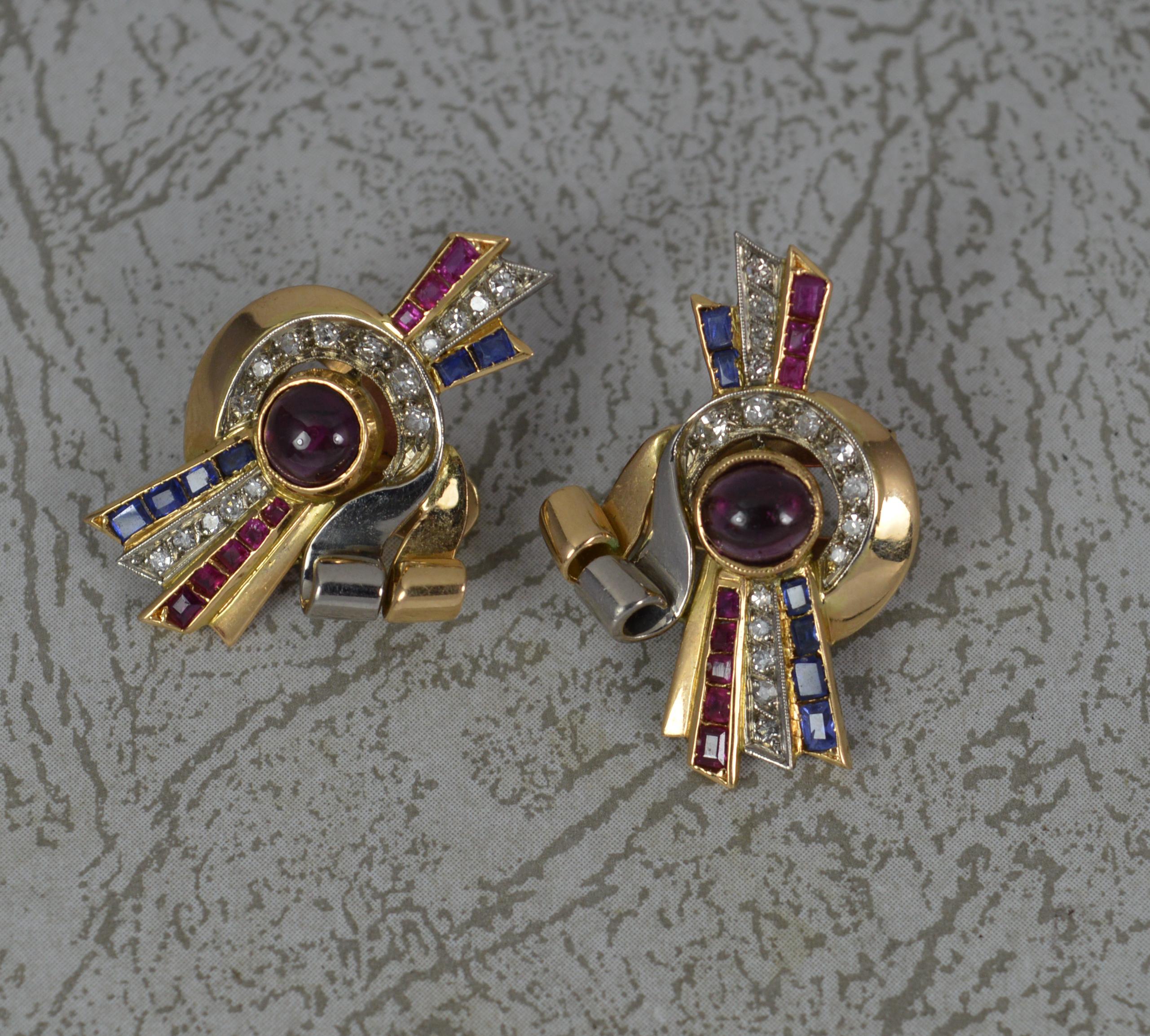 A superb pair of Art Deco period earrings, circa 1920.
Designed in 18 carat gold and platinum front sections.
A highly stylish design. The centre with a round ruby cabochon to centre in full bezel setting. To the sides are many princess cut blue
