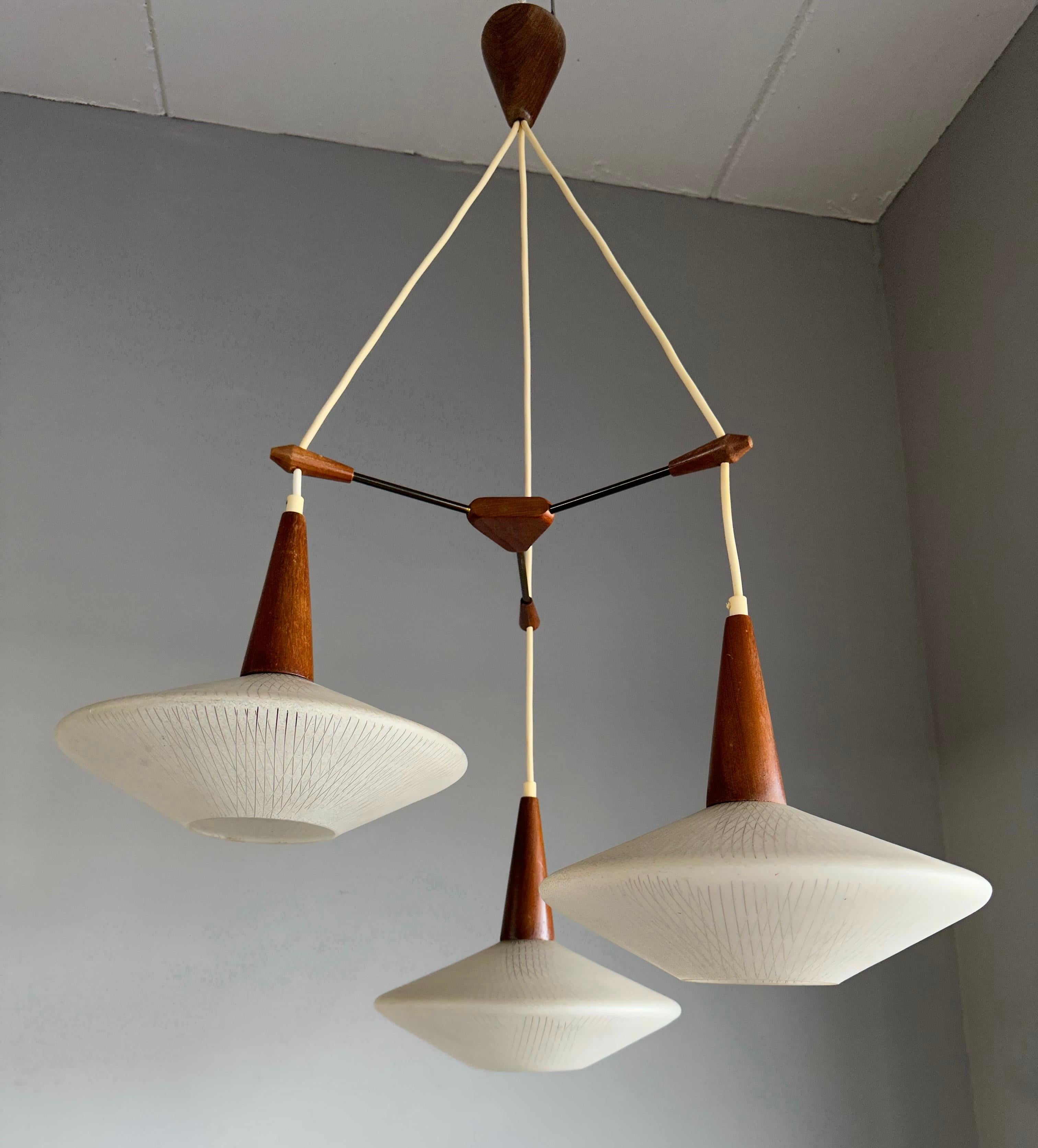 Wonderful Mid-Century Modern ceiling light with teakwood and art glass shades.

This vintage light fixture has a beautiful look and feel and you will hardly ever find a light fixture from the Mid-Century Modern era with more stylish or artistic