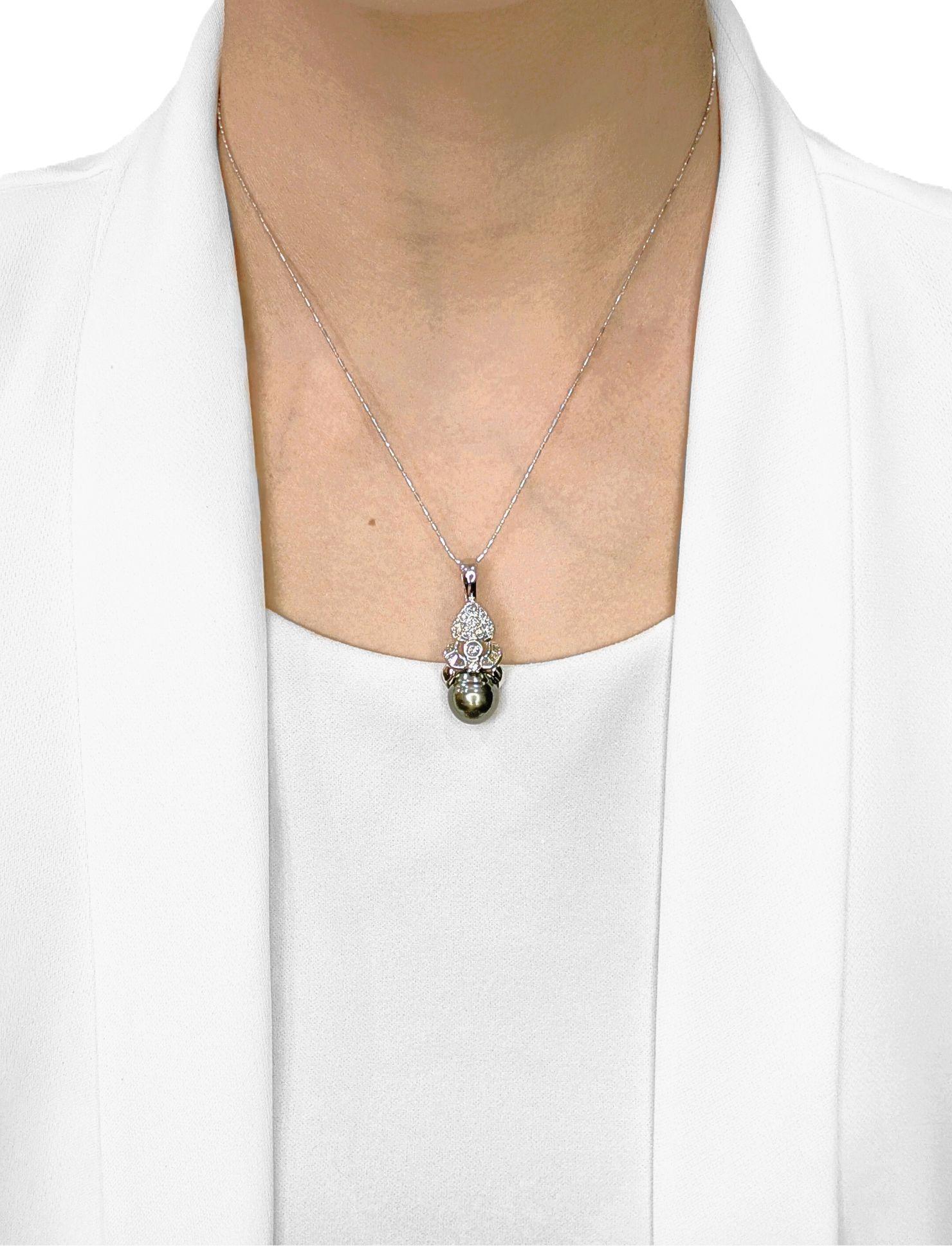 Ce nouveau pendentif, d'une élégance raffinée, met en valeur une perle de Tahiti ovale de 11 mm dans une teinte grise sophistiquée, sertie dans un corps en or blanc 18 carats avec un crochet en or blanc 14 carats pour une plus grande durabilité. La