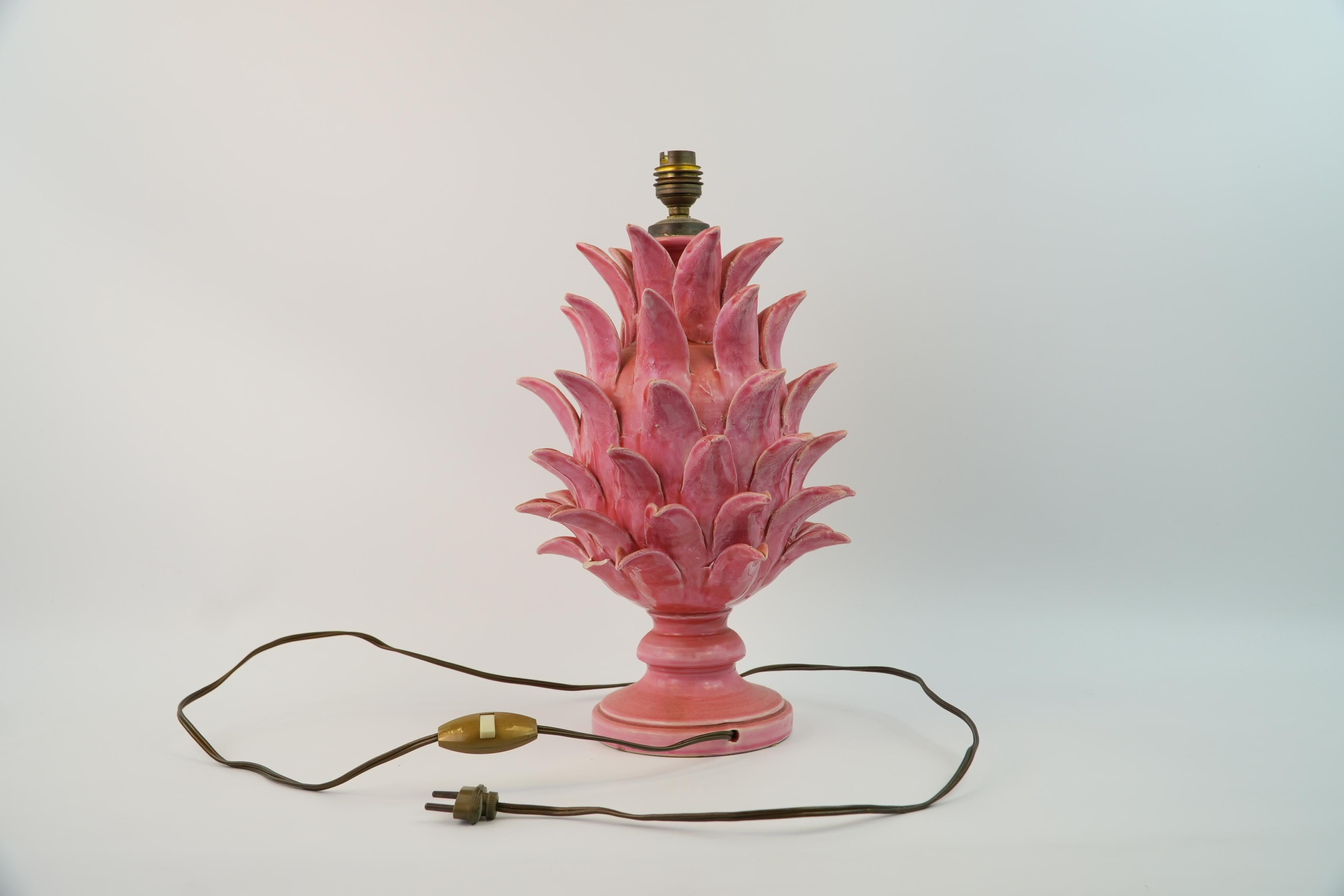 Cette lampe en céramique exquise de Jean Roger illustre l'esthétique organique caractéristique du céramiste français. Conçue sous la forme d'un ananas ou d'un artichaut stylisé, la lampe présente des feuilles superposées méticuleusement sculptées