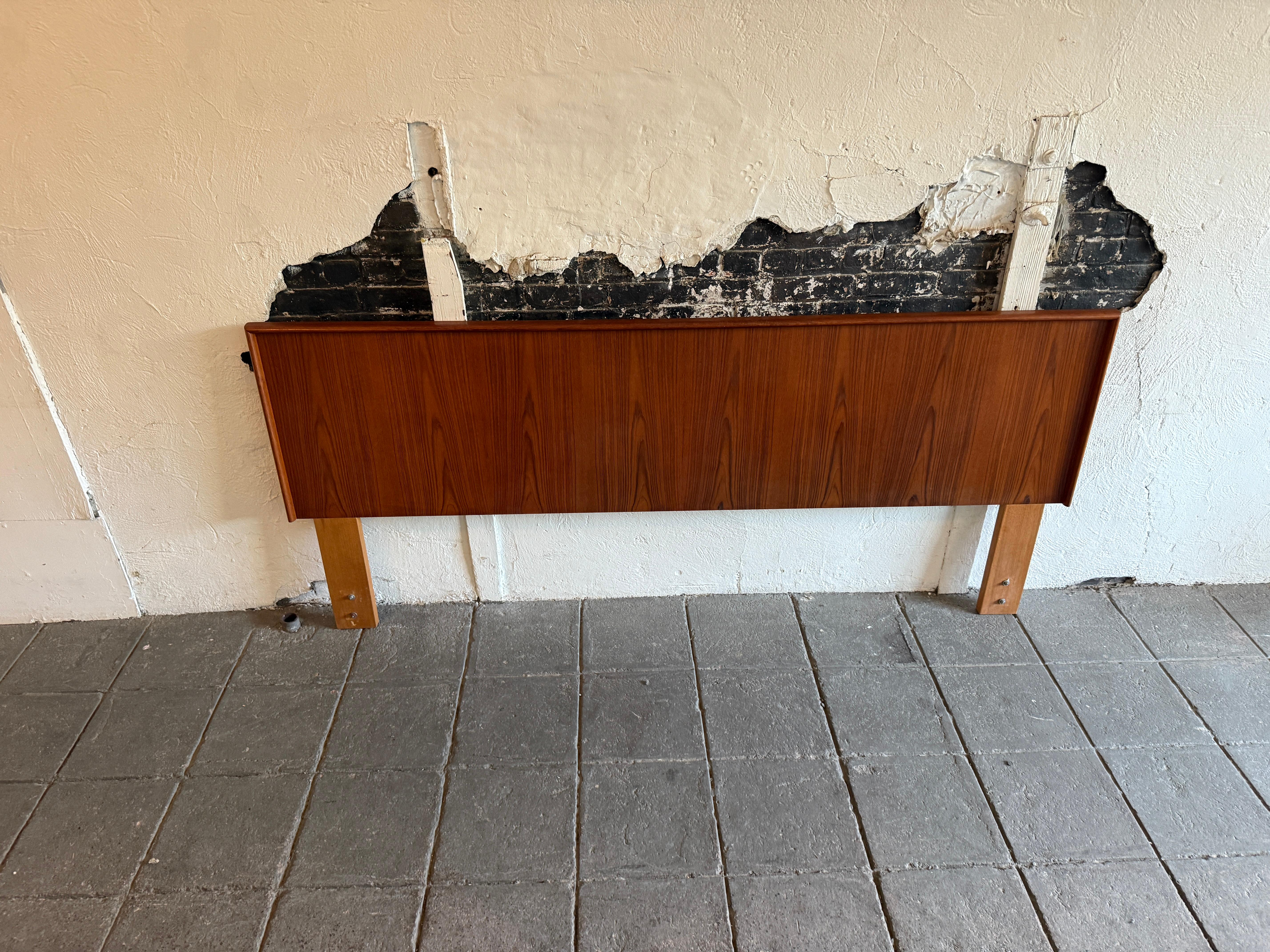 Stunning teak Danish Mid-Century Modern King headboard made in Denmark in wonderful condition. Really nice headboard with solid teak wood details. Fits a king sized mattress. Bed headboard only no metal bed frame or footboard. Easily mounts to all