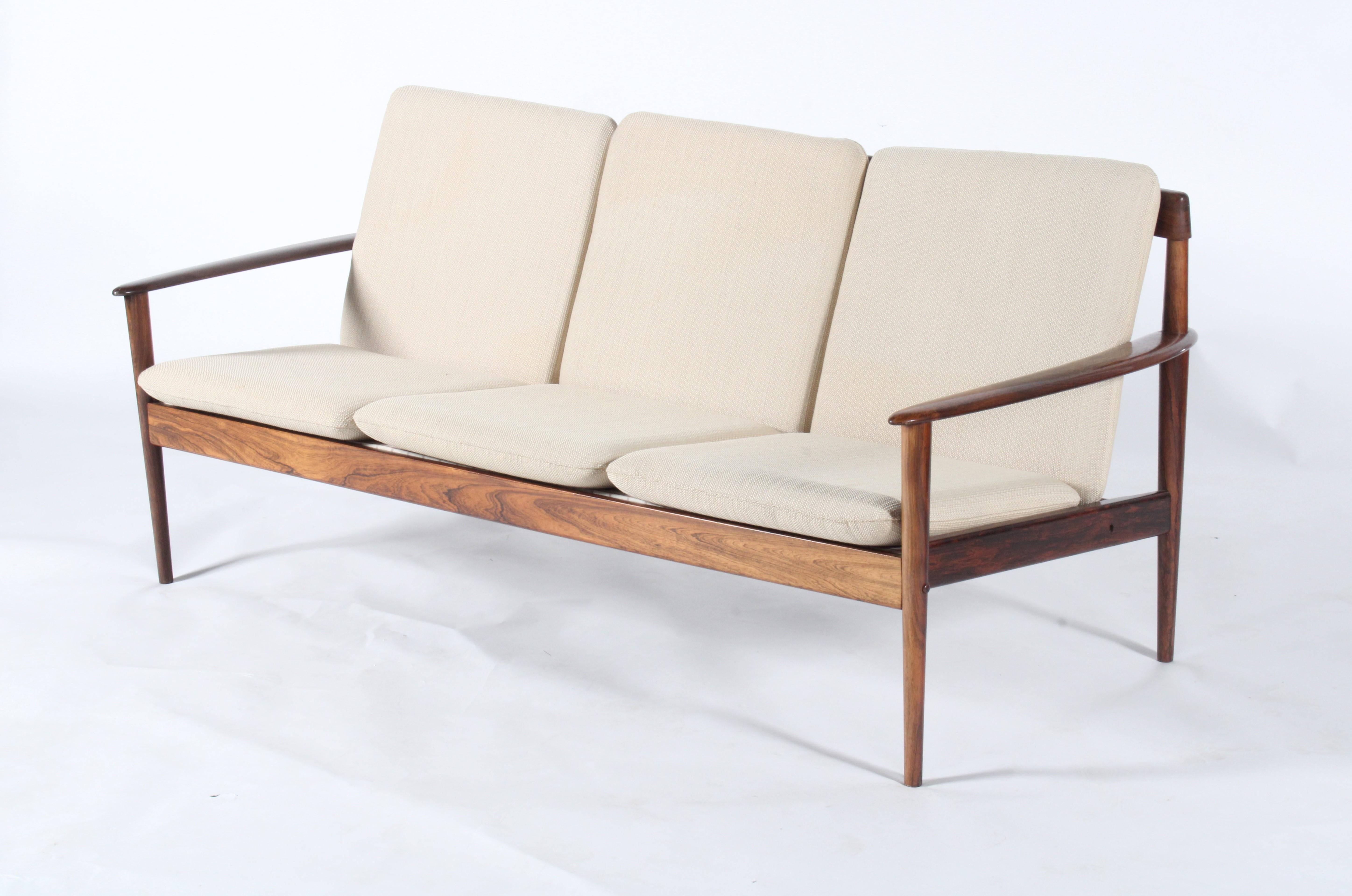 A stunningly beautiful sofa designed by the legendary Grete Jalk for Poul Jeppesen Mobelfabrik. Exceedingly rare in rosewood this piece has remarkable grain pattern and is presented in superb original vintage condition. A beautifully simple design