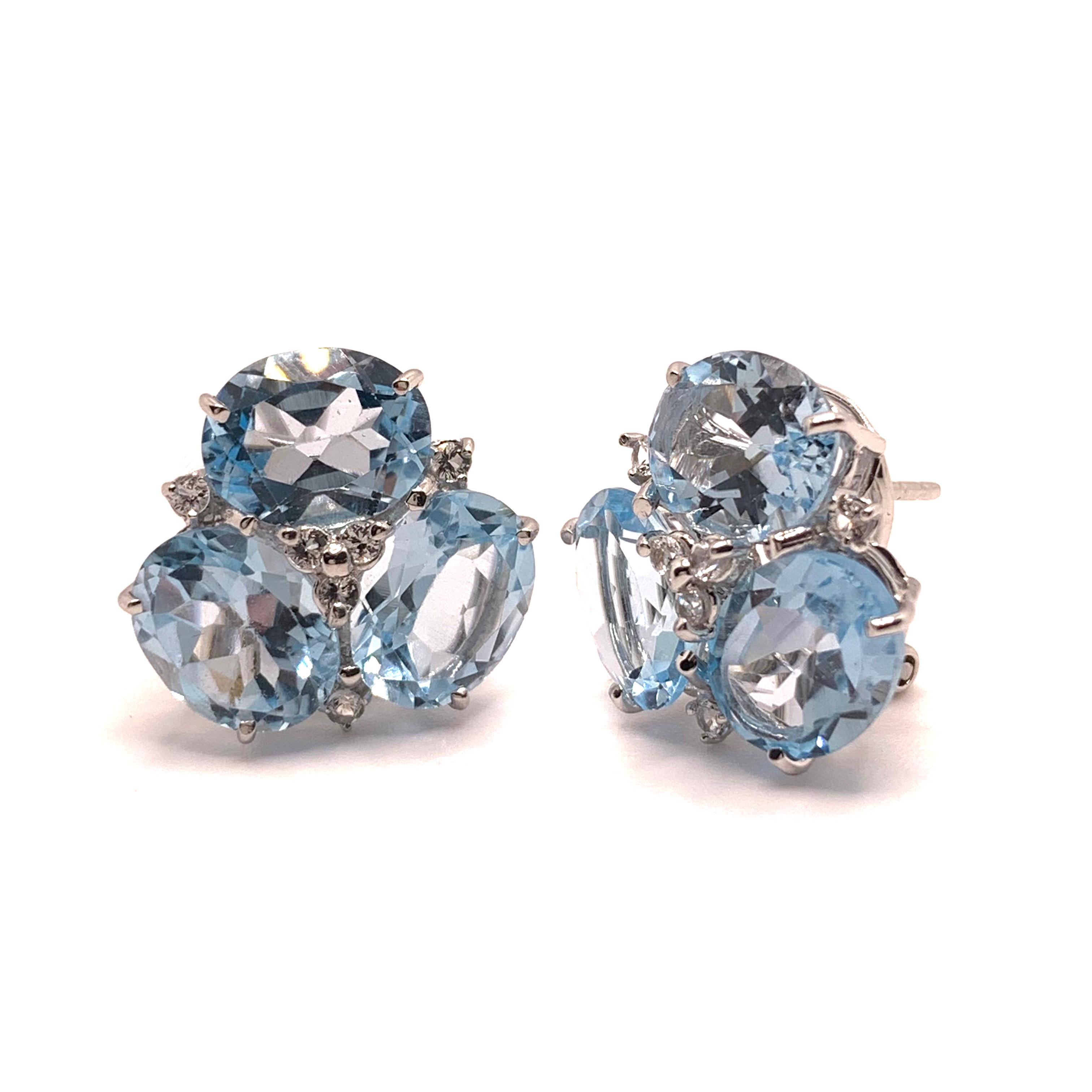 Cette paire de boucles d'oreilles étonnante présente des topazes ovales bleu ciel authentiques ornées de topazes blanches rondes, serties dans de l'argent sterling plaqué platine et rhodium. Nous aimons la couleur bleue douce de la topaze - elle