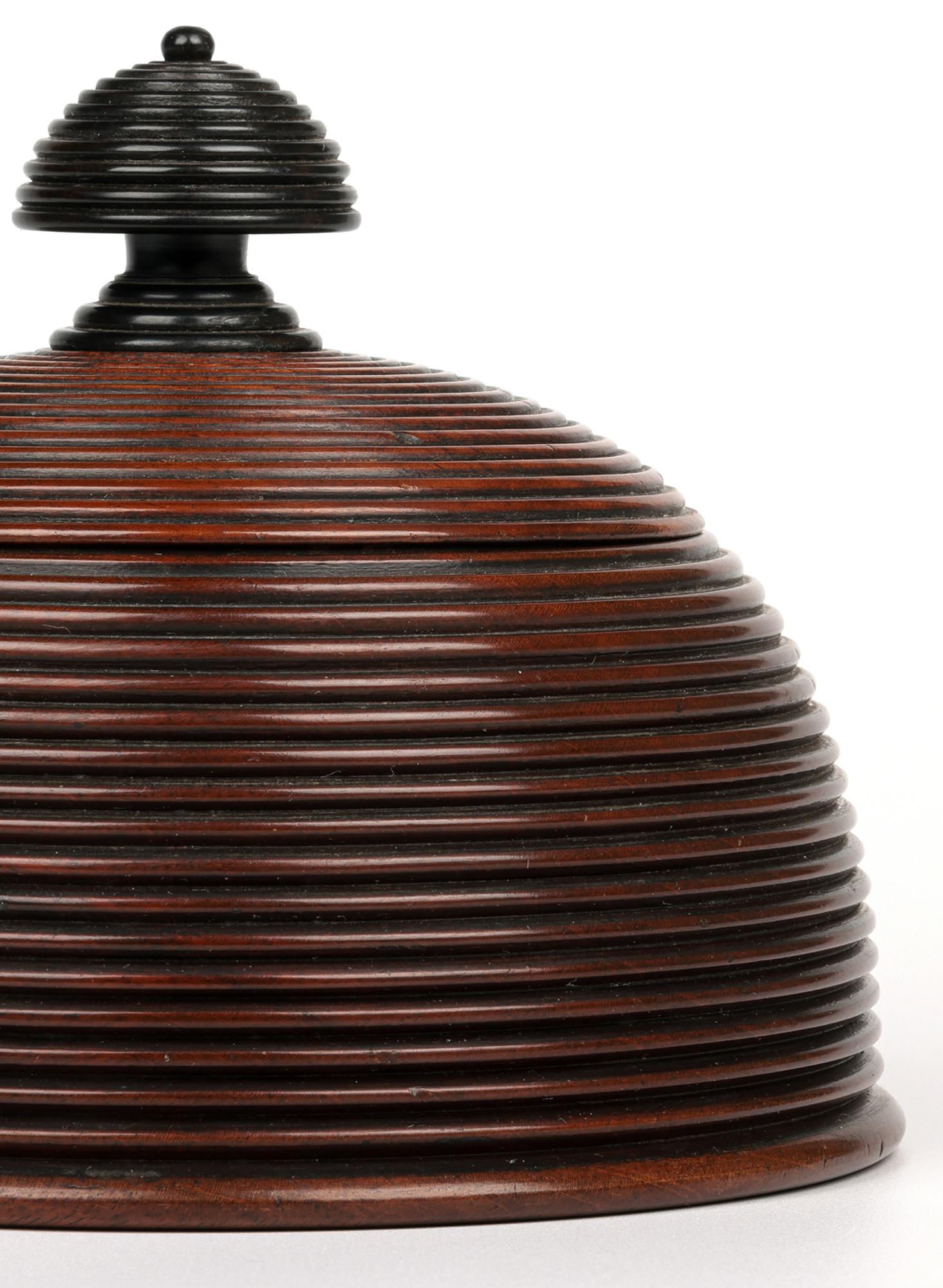 A stunning and unusual quality antique treen turnedr domed shape lidded container believed to date from the 19th century or early 20th Century. The turned hard wood container sits slightly raised on a wide round foot rim with slightly recessed base.