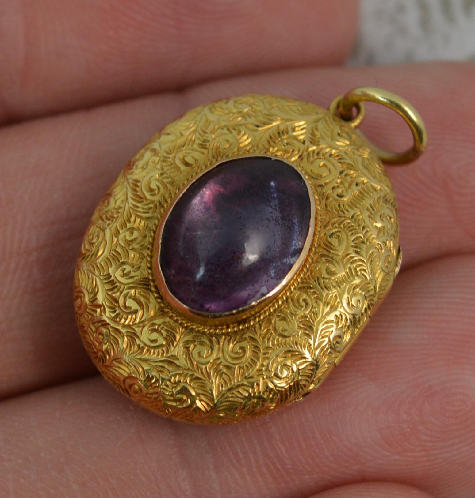 A true Victorian period pendant locket c1880.
Solid 15 carat yellow gold example.
Designed with a single oval cabochon amethyst on closed foiled pale pink back.
Very fine hand engraved pattern throughout.

CONDITION ; Excellent. Very crisp design.