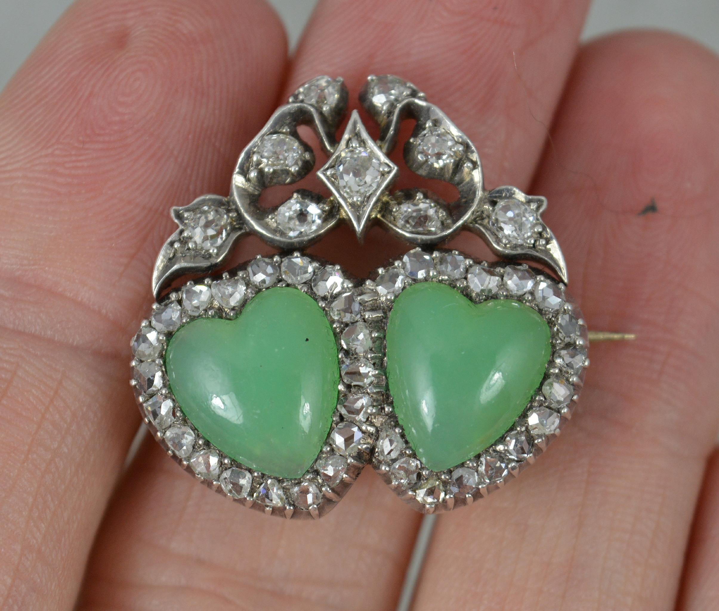 A stunning late Victorian period brooch. c1880.
Solid 15 carat gold example with silver head front setting.
The piece has been designed as two heart shaped chrysoprase stones. 9mm x 10mm each. 
Set with over 40 natural rose and old cut diamonds