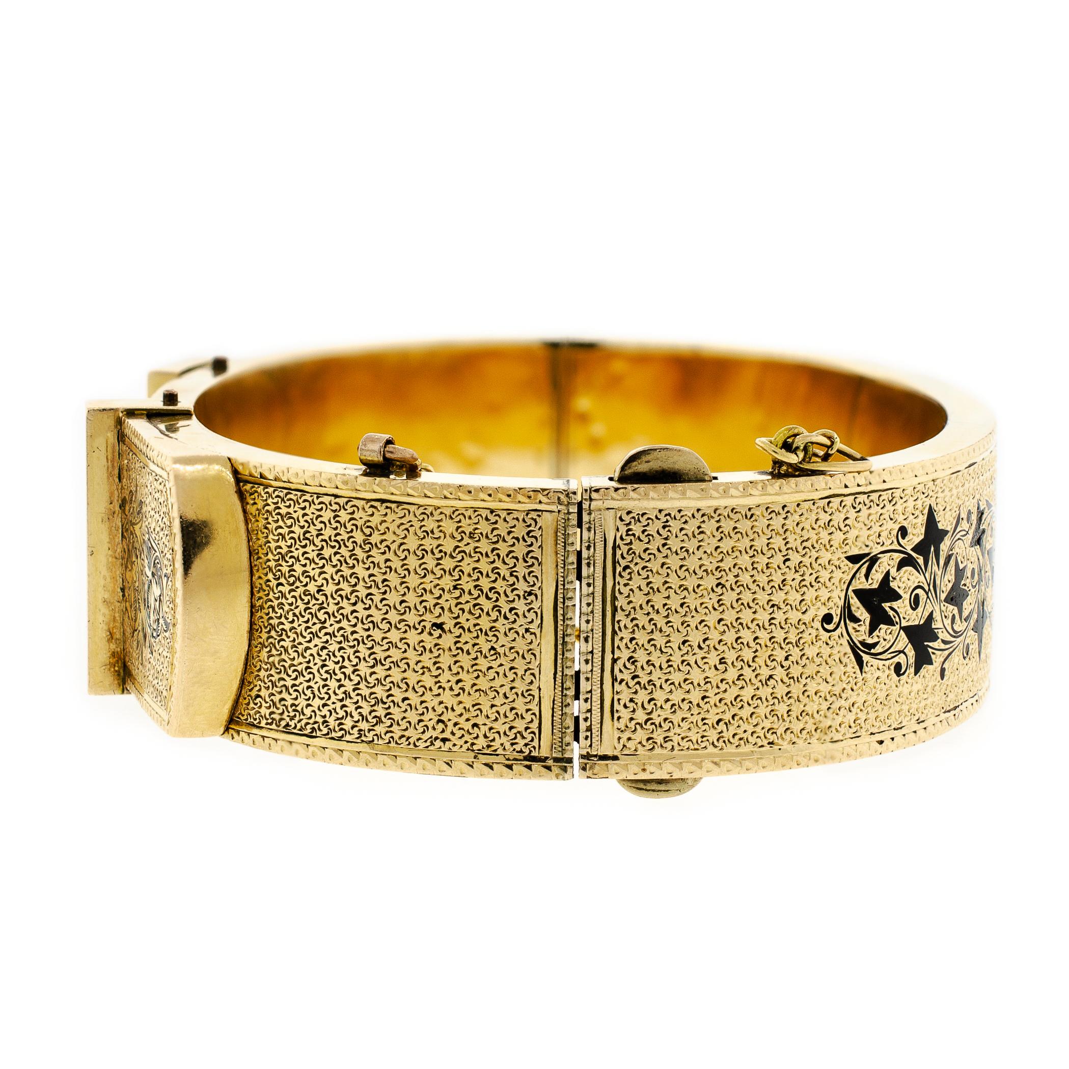 Stunning Victorian buckle motif yellow gold buckle stiff hinged bangle bracelet accented with black enamel detail stippled textured embossed foliate designs yellow gold safety chain hinged side clasp 3/4