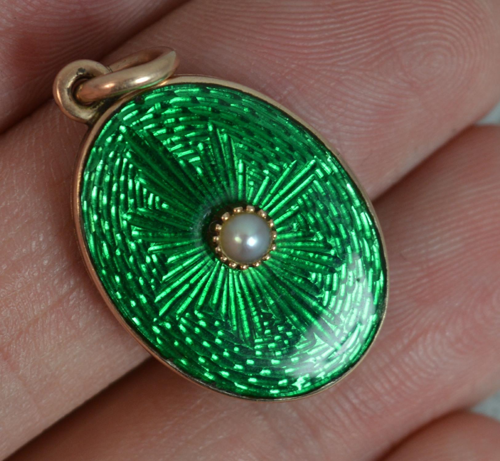 A stunning Victorian period locket pendant.
Modelled in rose gold with a glass locket compartment to reverse.
The front designed with a pearl set to centre of a very bright vivid green enamel with star pattern.
c1880.

CONDITION ; Excellent for age.