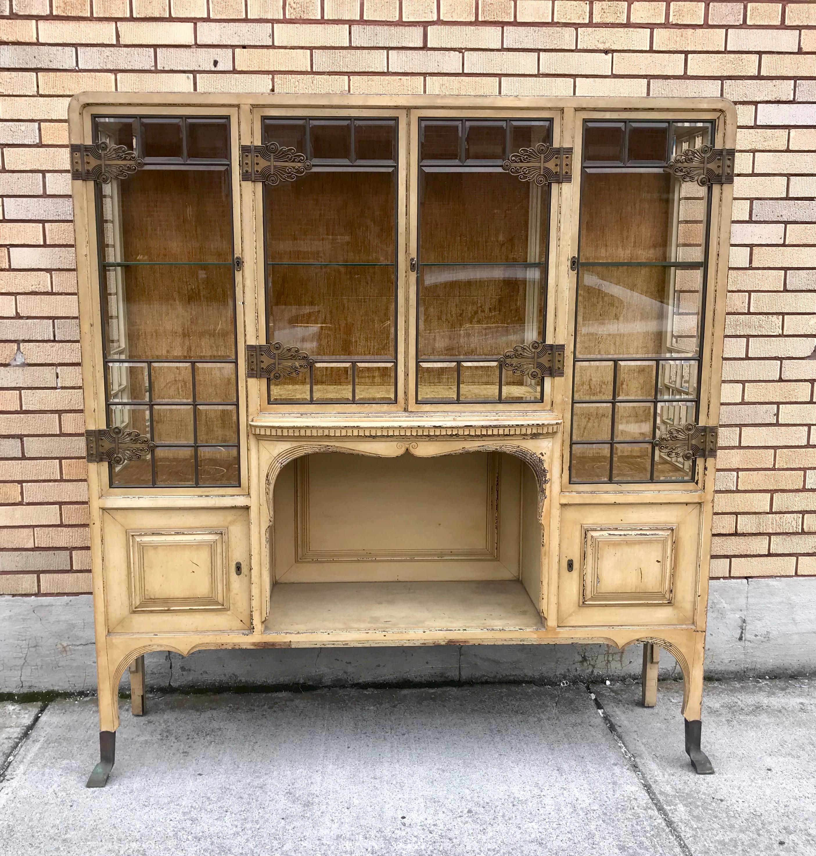 Stunning beveled glass cabinet / etagere. Originally purchased out of fabulous estate in New York City. Stunning appointments and detail. Thick copper beveled glass doors and sides, 3 glass shelves on brass rails, heavy brass Art Deco hasp door