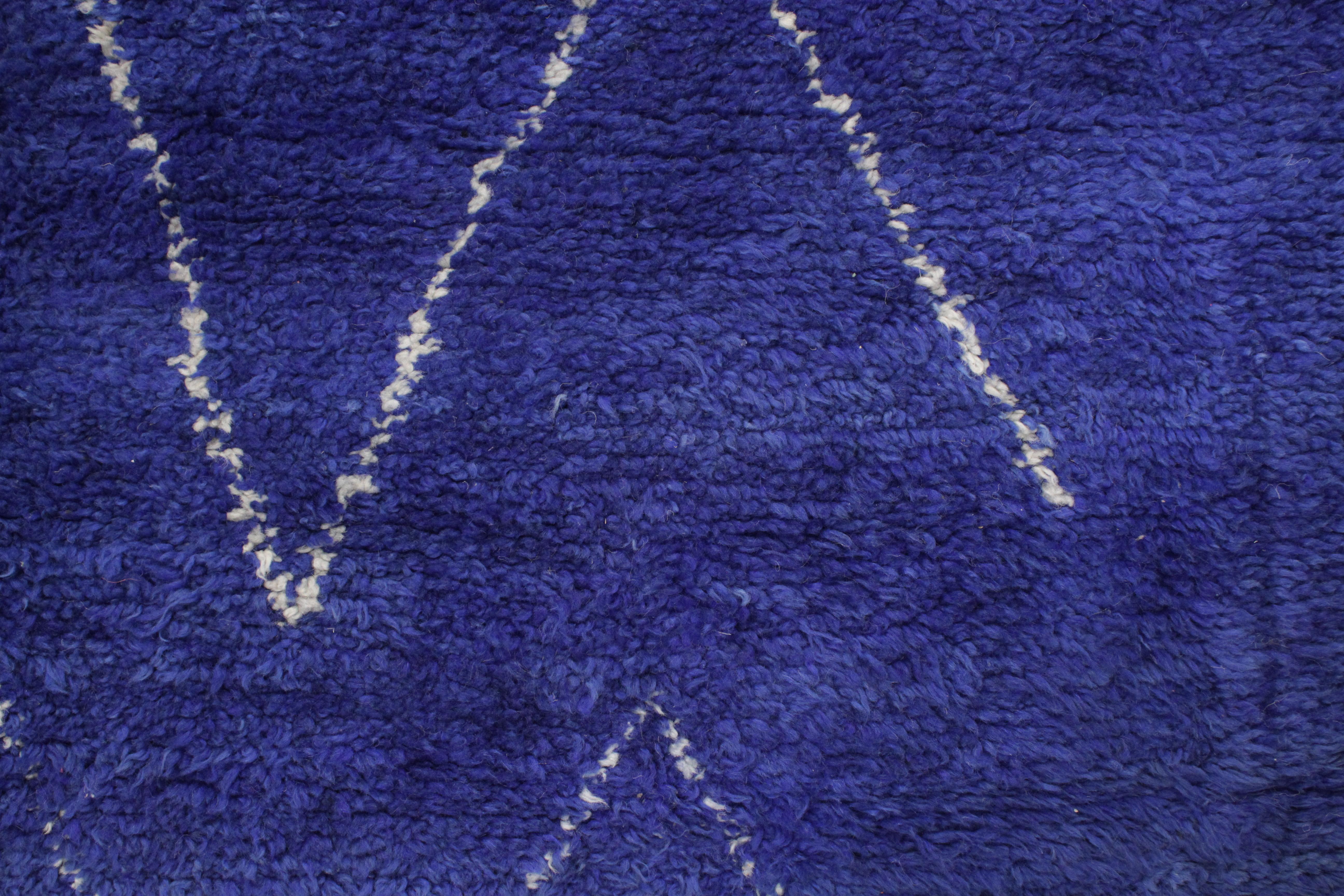 Die Teppiche des Beni Mguild-Stammes, der im marokkanischen Mittleren Atlasgebirge lebt, zeichnen sich oft durch reiche einfarbige Farbtöne aus, typischerweise in Rot- oder Blautönen. Sie sind mit lanolinreicher Wolle aus dem Atlasgebirge gewebt und