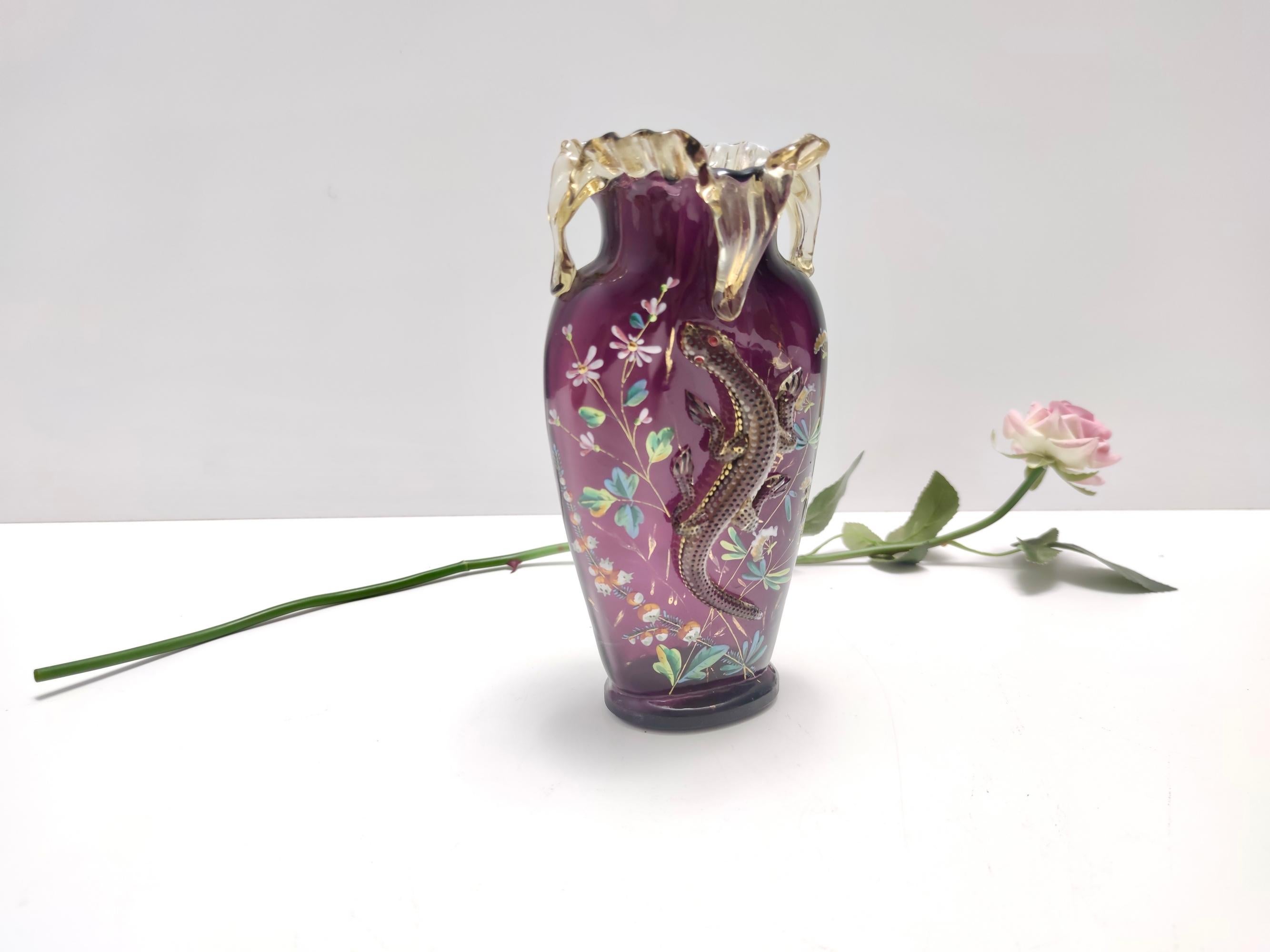 1890s. Probably made in Bohemia or in a Northern European country.
This beautiful blown glass vase is rendered in a lovely amethyst color.
It features a modeled glass salamander, applied with a melting technique, and a glazed floral decoration.