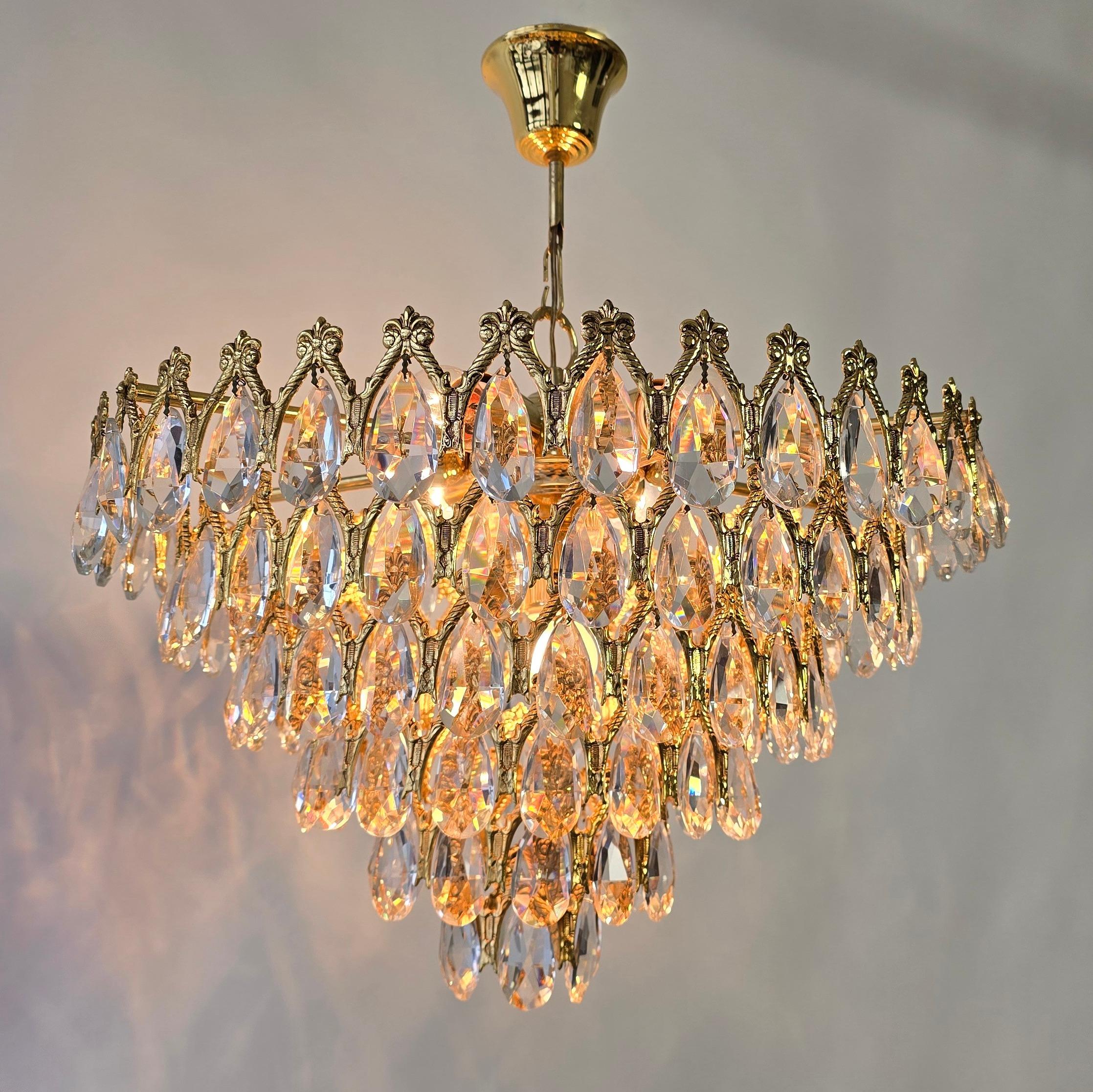Stunning Vintage Chandelier with Large Teardrop Crystals – Spain, 1970s

This exquisite chandelier, richly adorned with dazzling crystals, originates from Spain and dates back to the late 1960s or early 1970s. Its structure is crafted from