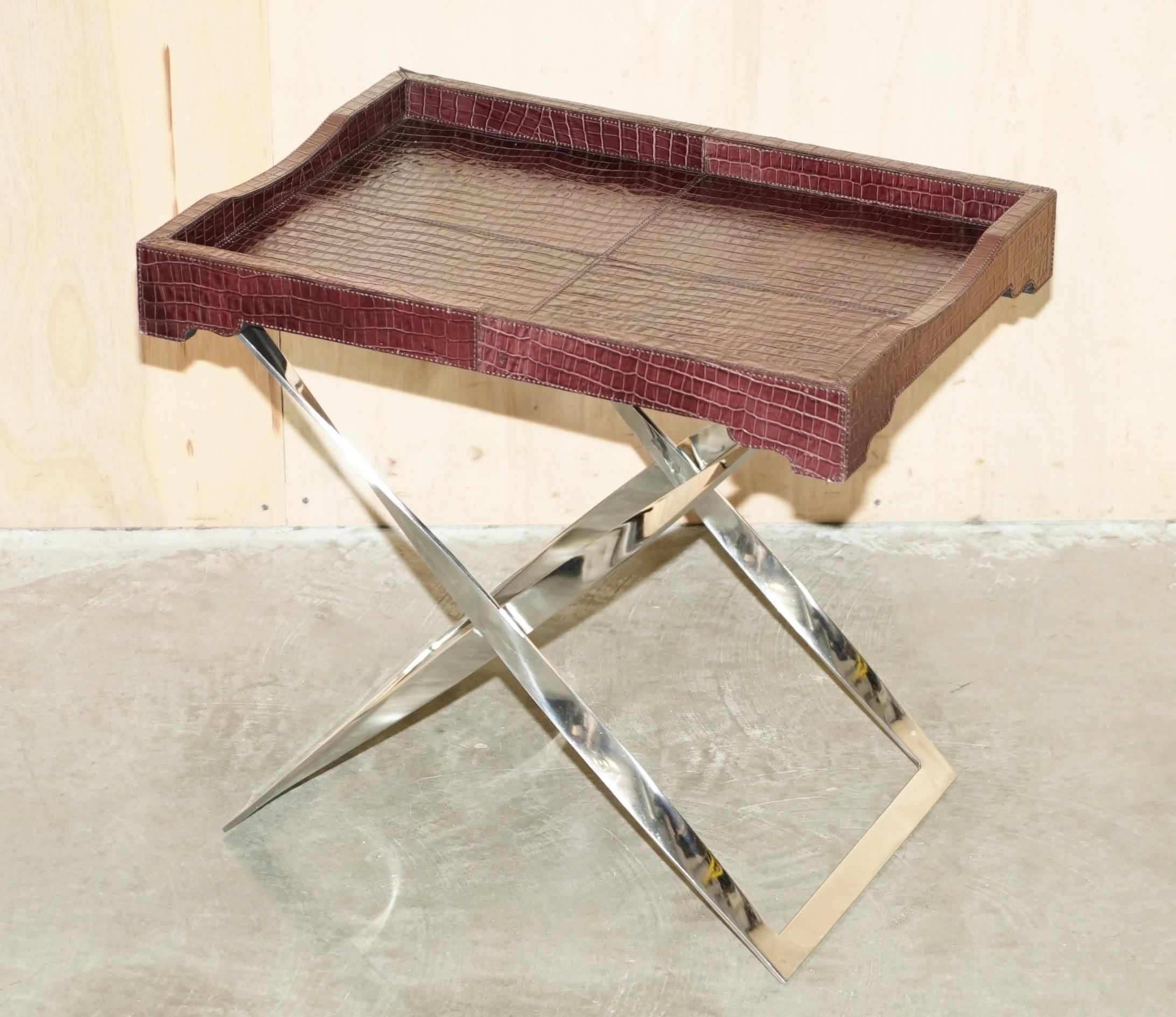 The House Antiques a le plaisir d'offrir à la vente cette superbe table à plateau pliante, faite à la main, en cuir de crocodile patiné, avec une base chromée sculptée.

Veuillez noter que les frais de livraison indiqués sont donnés à titre
