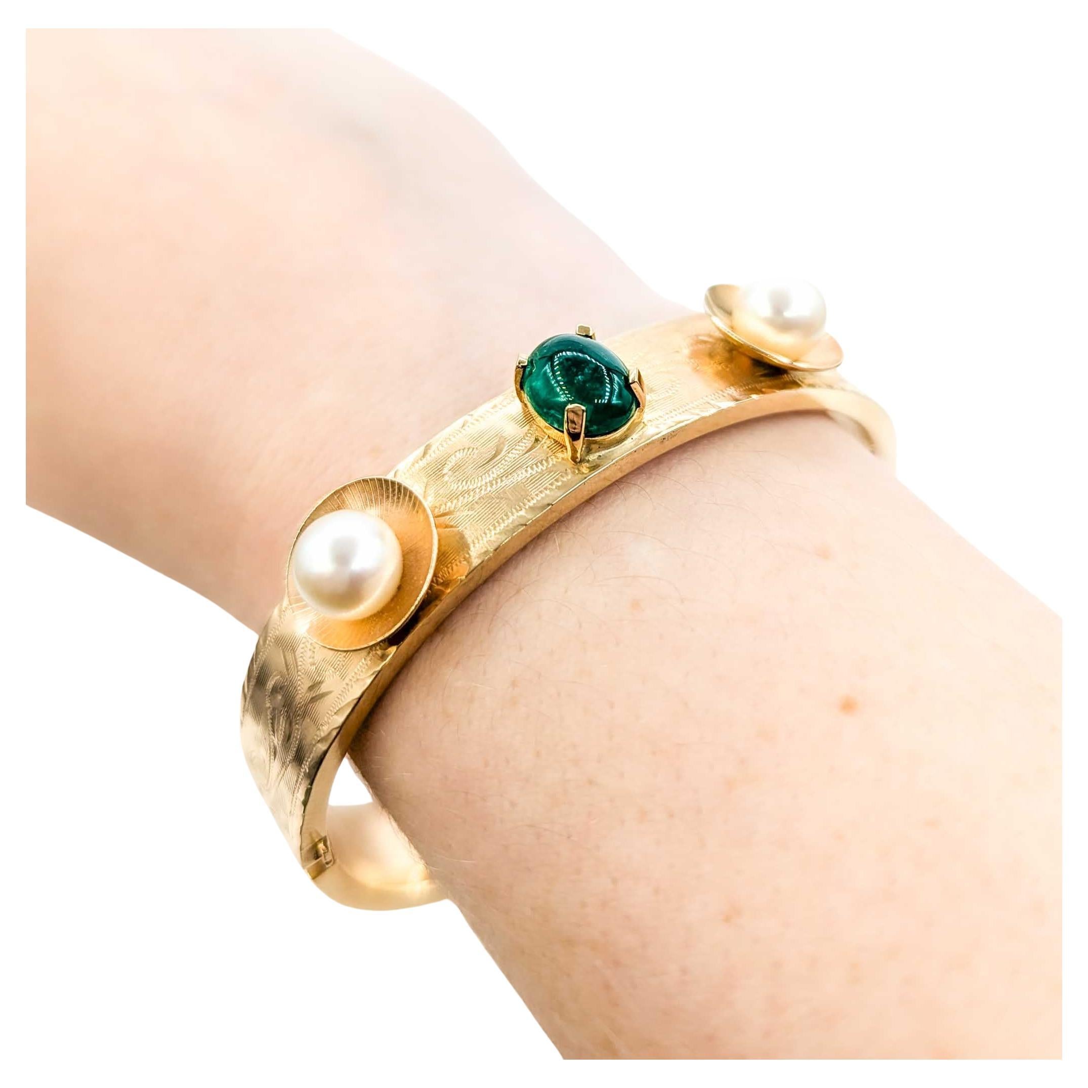 Superbe bracelet jonc vintage à charnières en or jaune MCM

Voici ce magnifique bracelet à charnière en or jaune 14k, orné d'émeraudes et de perles. Le bracelet présente une superbe émeraude cabochon de 2,20ct associée à deux perles lumineuses des