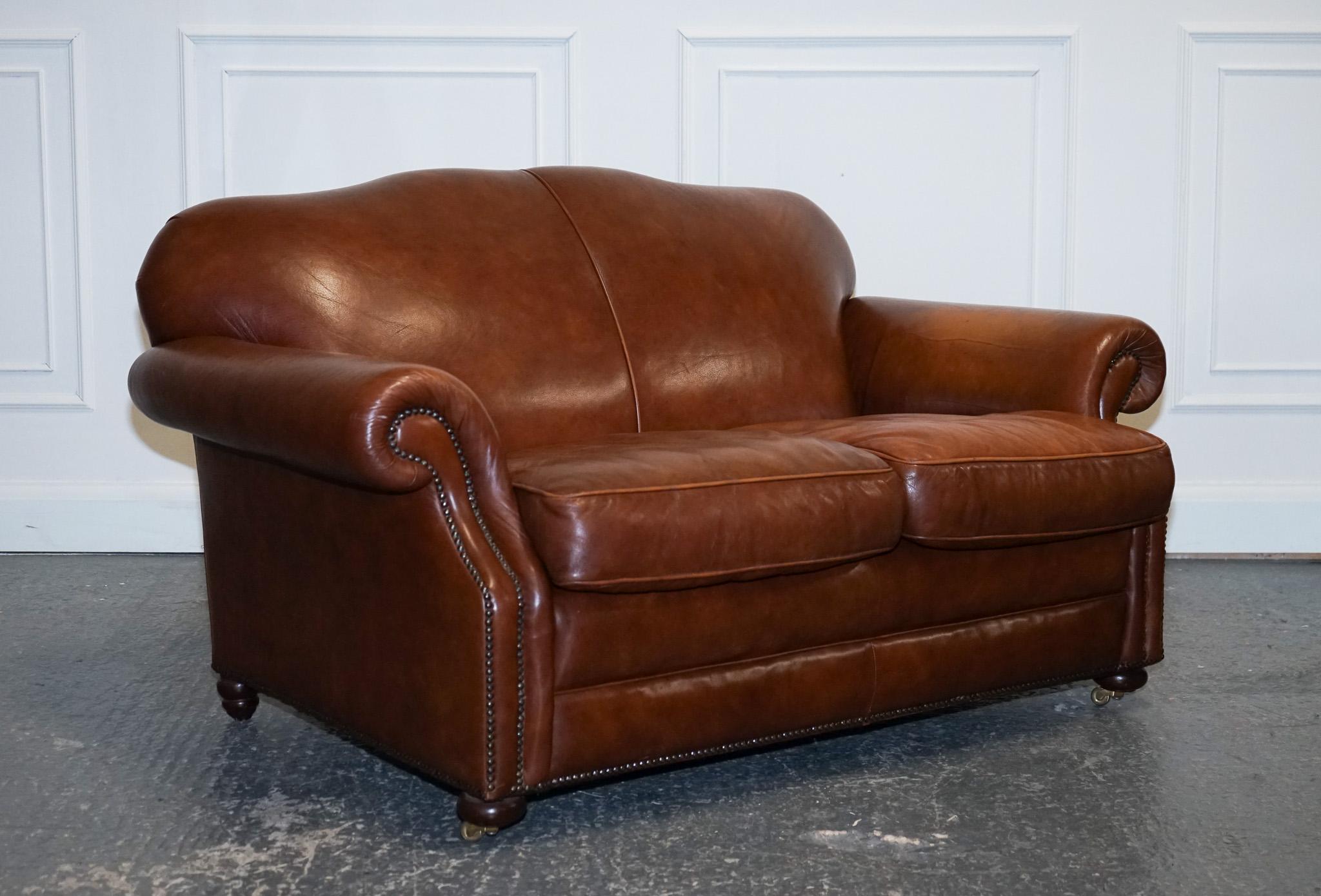 We are delighted to offer for sale this Beautiful Laura Ashley Brown Leather Hump Back Sofa.

The vintage Laura Ashley brown leather hump-back sofa with studs is a stunning statement piece that combines classic design elements with edgy detailing.