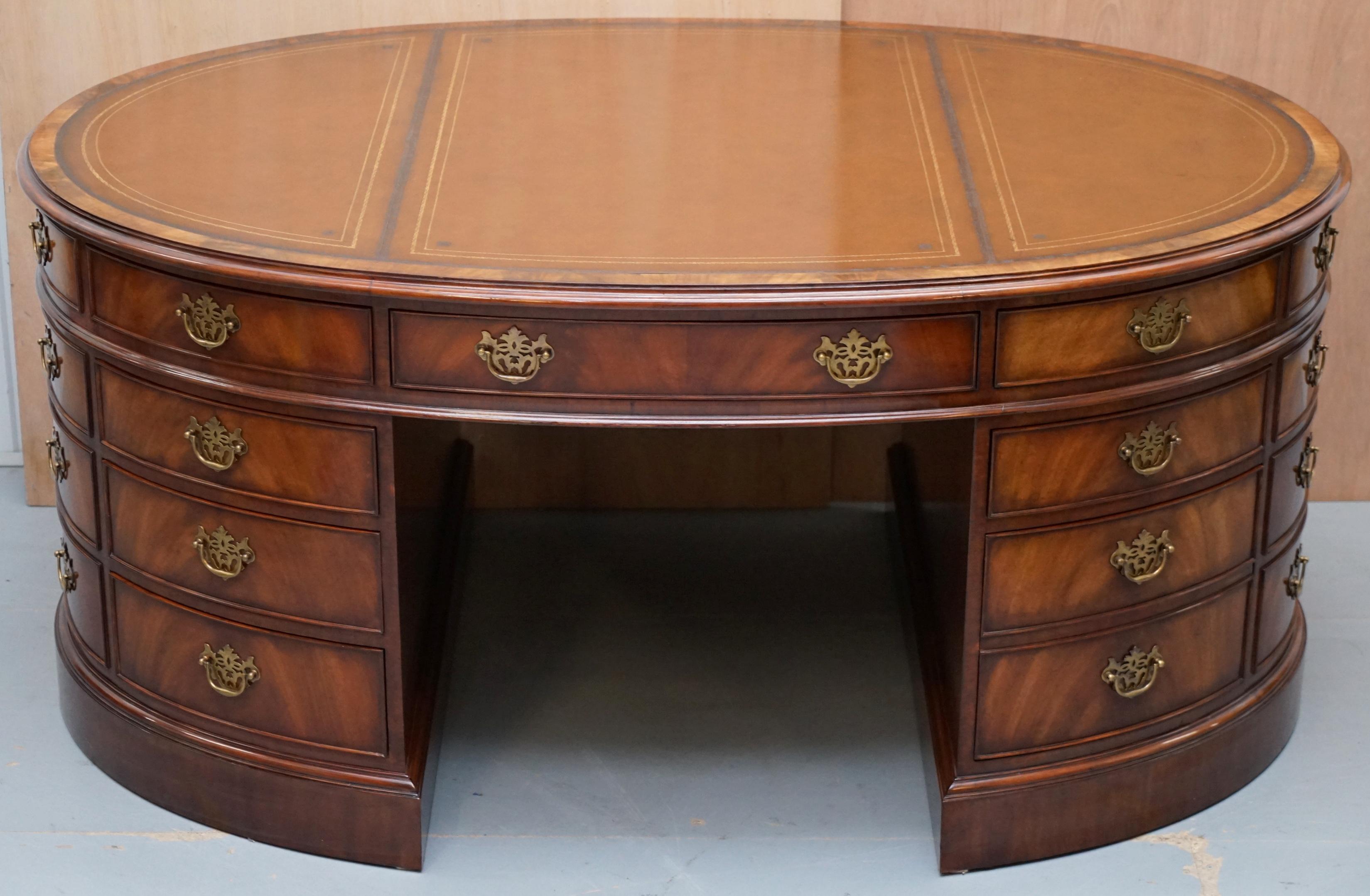 We are delighted to this absolutely stunning Crotch Mahogany Oval Partners desk with brass handles and gold leaf embossed antique Brown Leather writing surface 

A truly exquisite piece, the desk is double sided so designed for two people to share